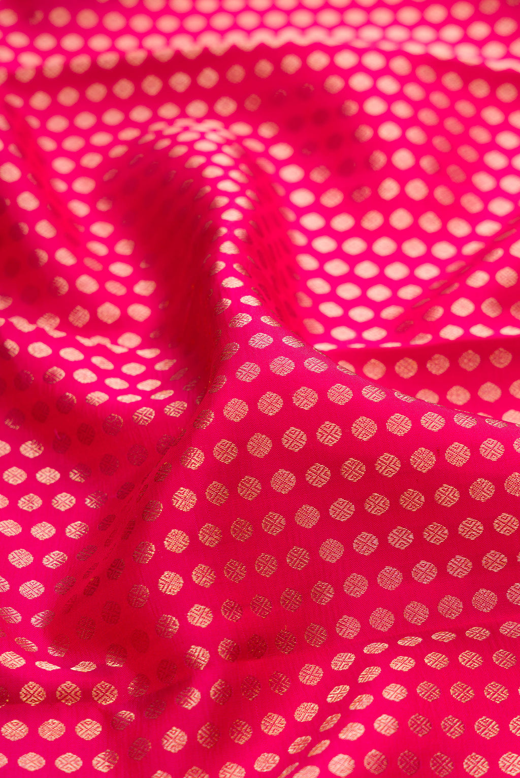 Close up of Dark Pink Kanchipuram Silk Saree with Zari Brocade on the body and Zari Border.  displaying folds