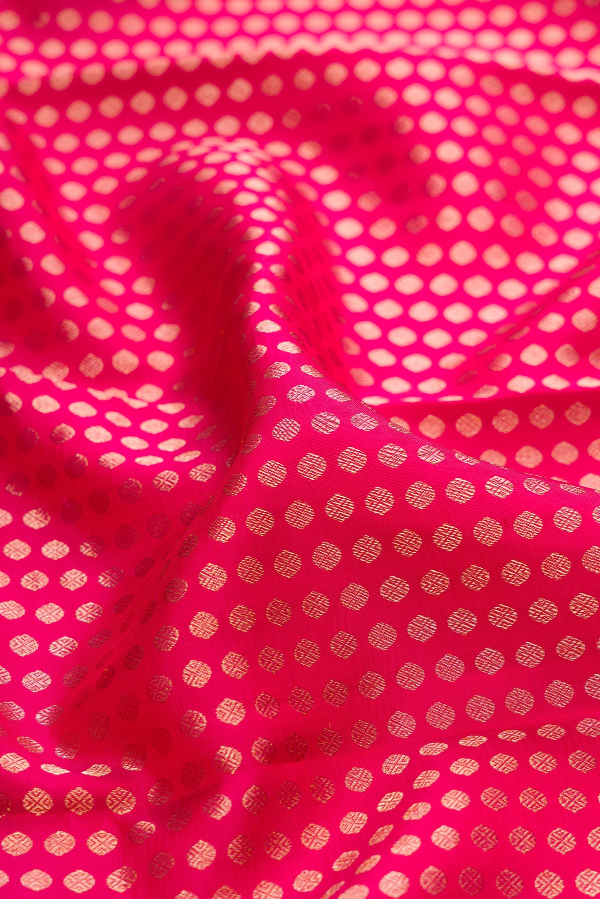 Close up of Dark Pink Kanchipuram Silk Saree with Zari Brocade on the body and Zari Border.  displaying folds