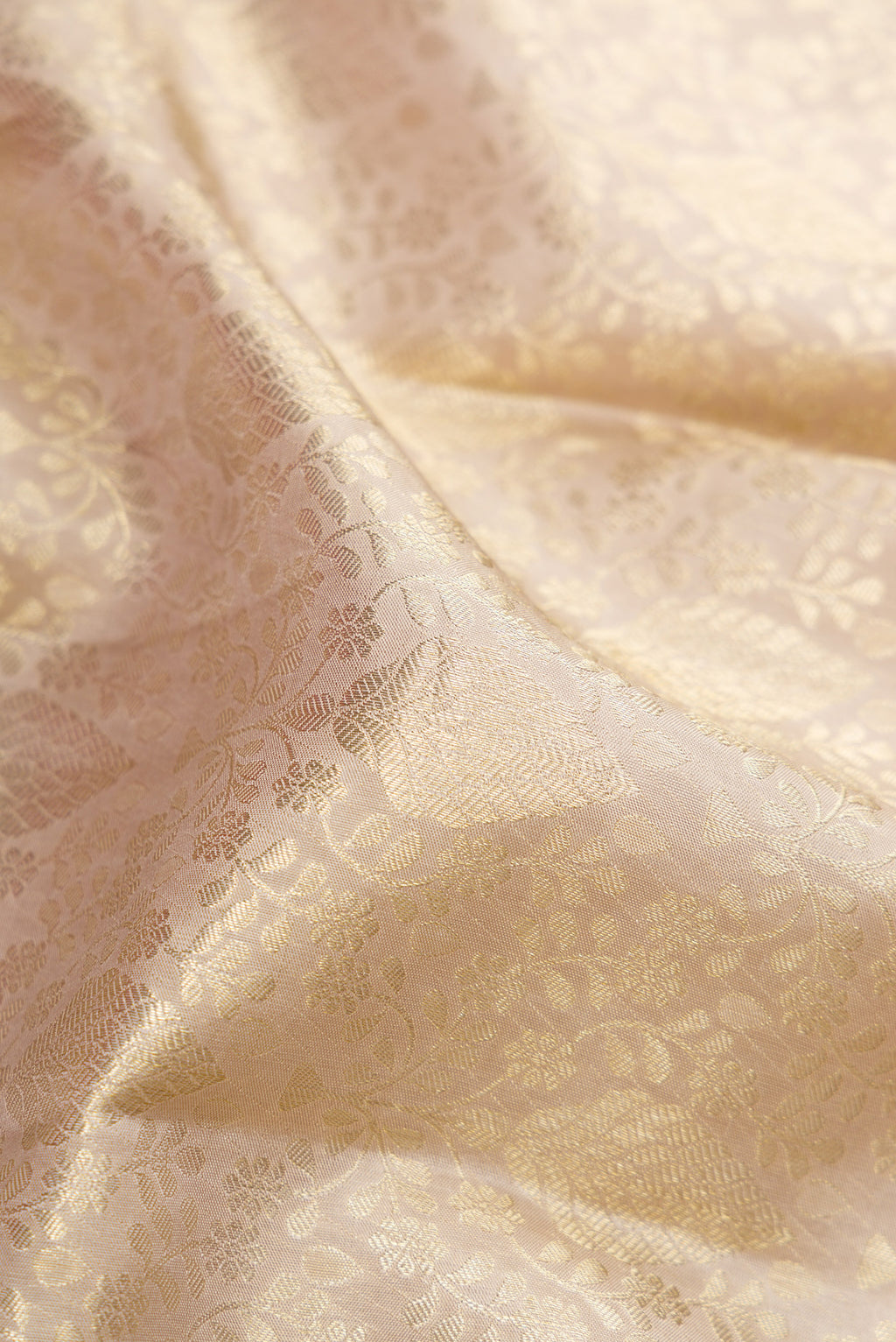Close up of Off White Kanchipuram Silk Saree with Zari Brocade on the body and Zari Border.  displaying folds