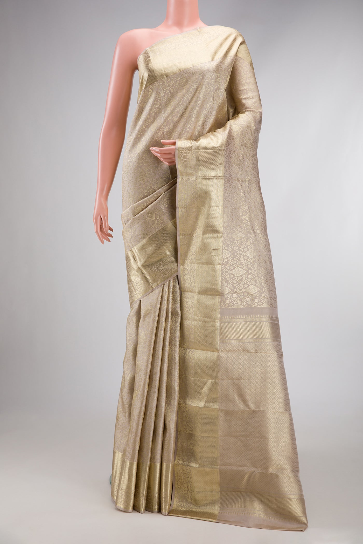 Off White Kanchipuram Silk Saree with Zari Brocade on the body and Zari Border.  displayed on a mannequin