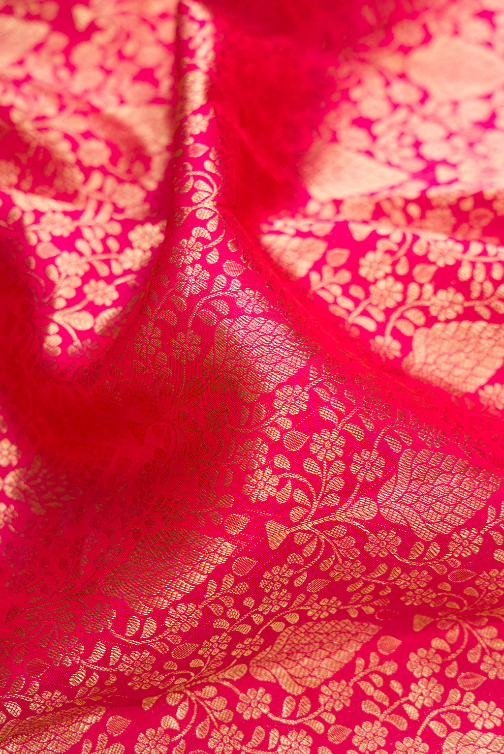 Close up of Dark Pink Kanchipuram Silk Saree with Zari Brocade on the body and Zari Border.  displaying folds