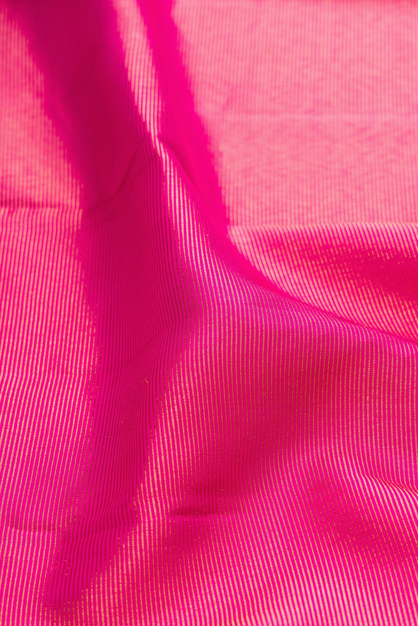 Close up of Rani Pink Dual Tone Kanchipuram Silk Saree with Zari Brocade on the body and Zari Border.  displaying folds