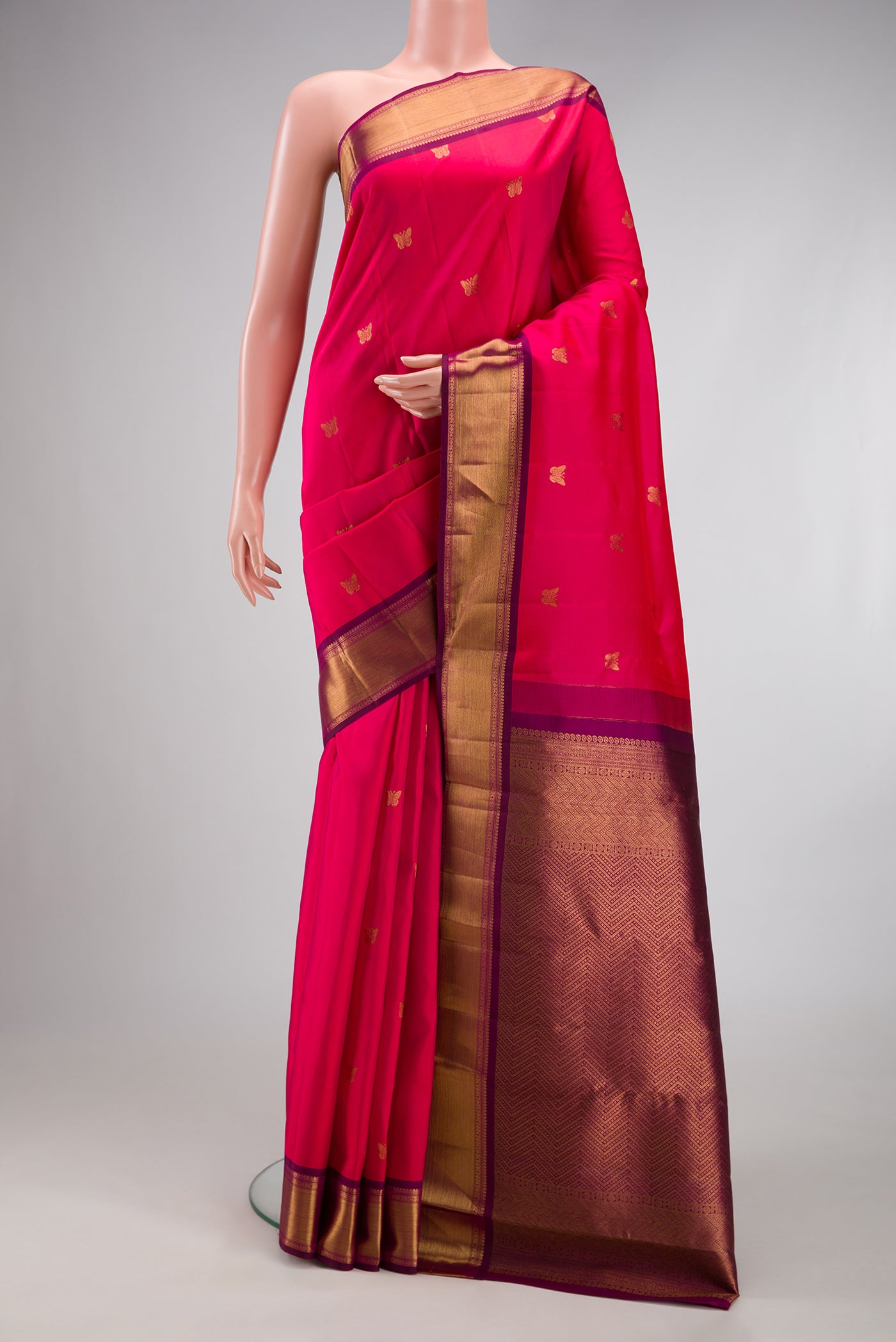 Dark Pink Kanjivaram Silk Saree with Zari Butta on the body and Zari Border.  displayed on a mannequin