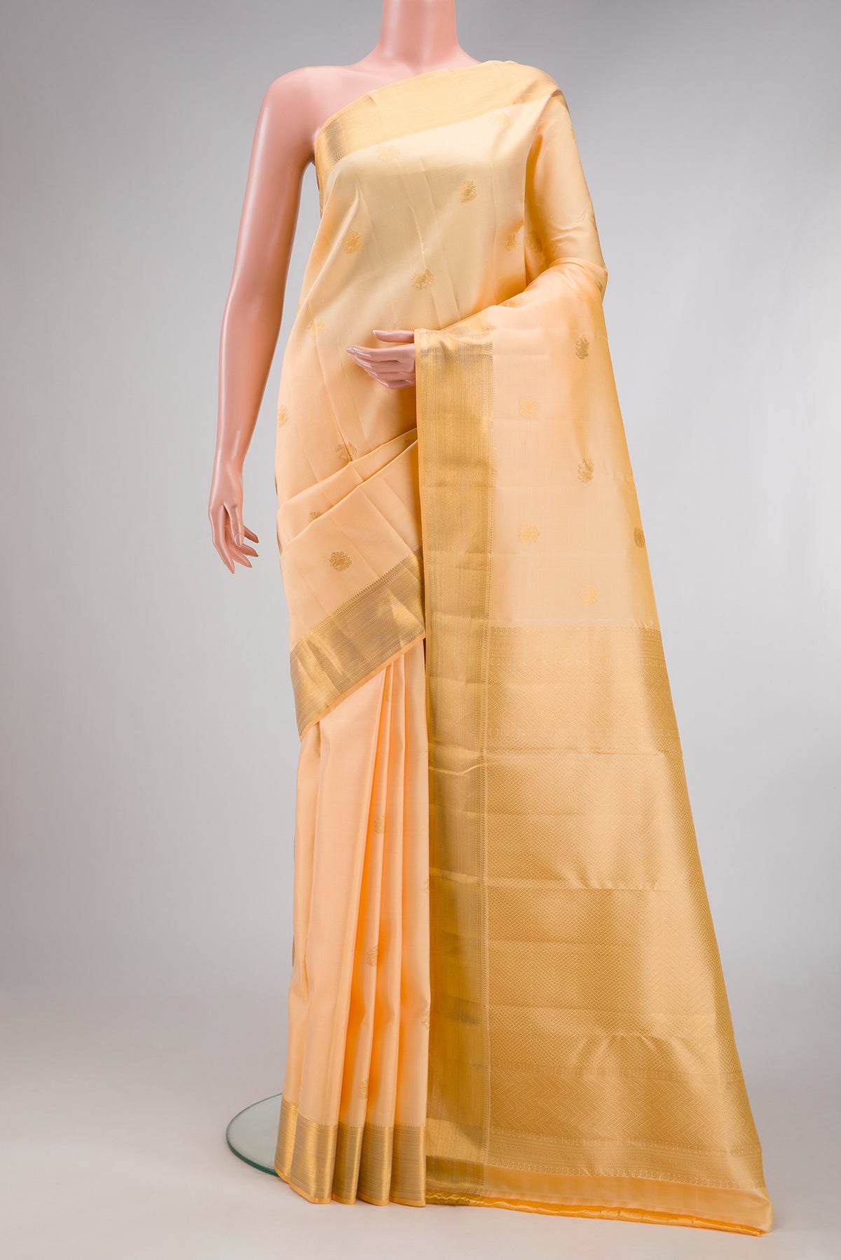 Sandal Kanjivaram Silk Saree with Zari Butta on the body and Zari Border.  displayed on a mannequin