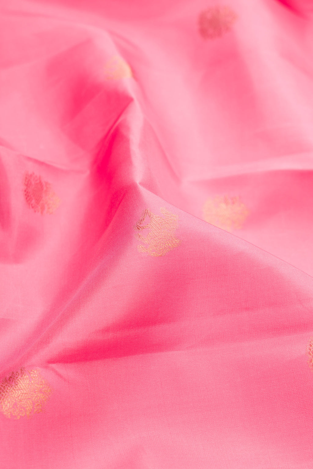 Close up of Rose pink Kanchipuram Silk Saree with Zari Butta on the body and Zari Border.  displaying folds