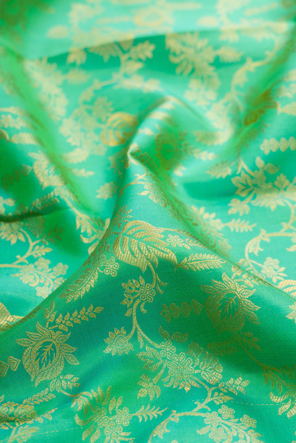 Close up of Green Kanchipuram Silk Saree with Zari Brocade on the body and Zari Border.  displaying folds