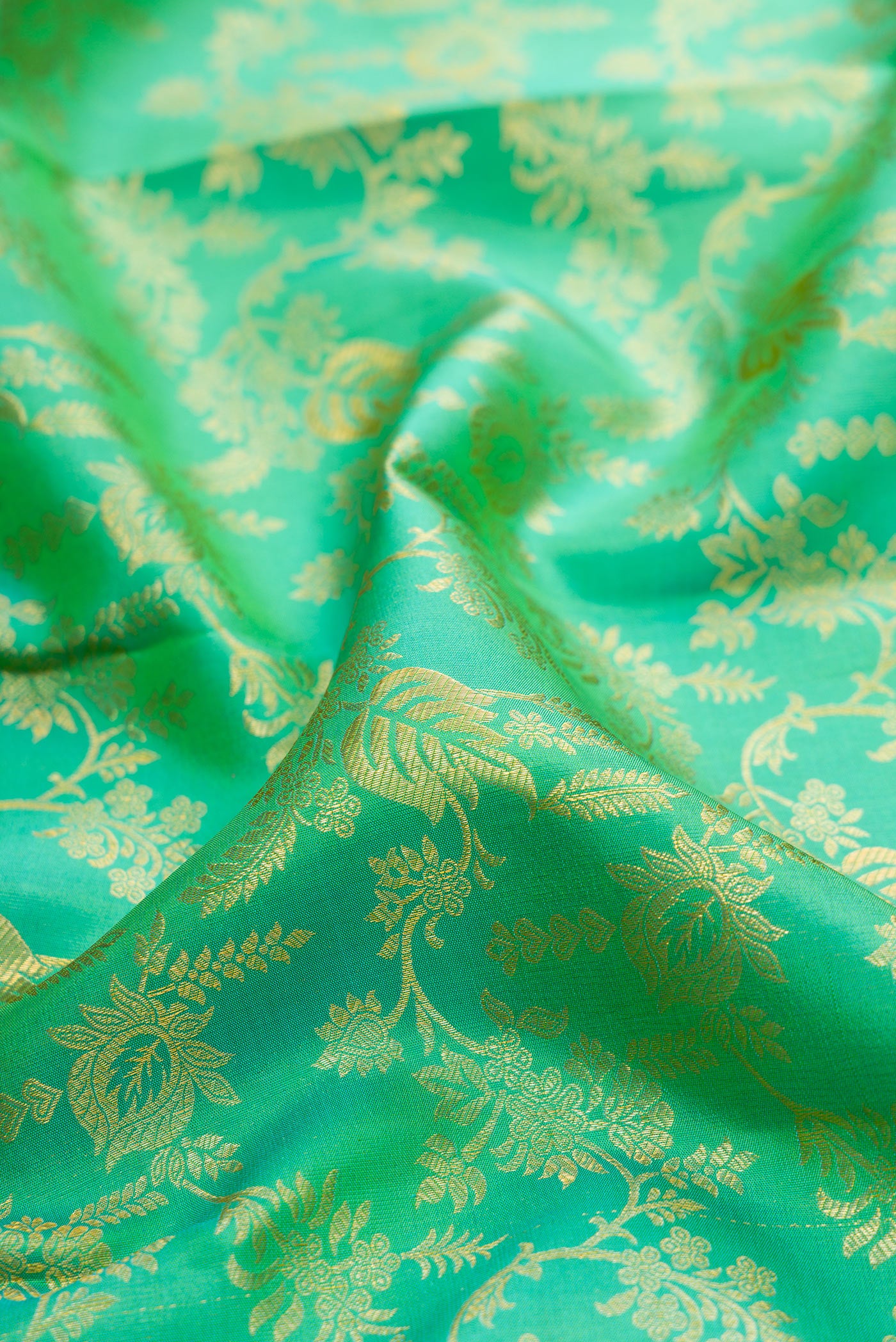 Close up of Green Kanchipuram Silk Saree with Zari Brocade on the body and Zari Border.  displaying folds