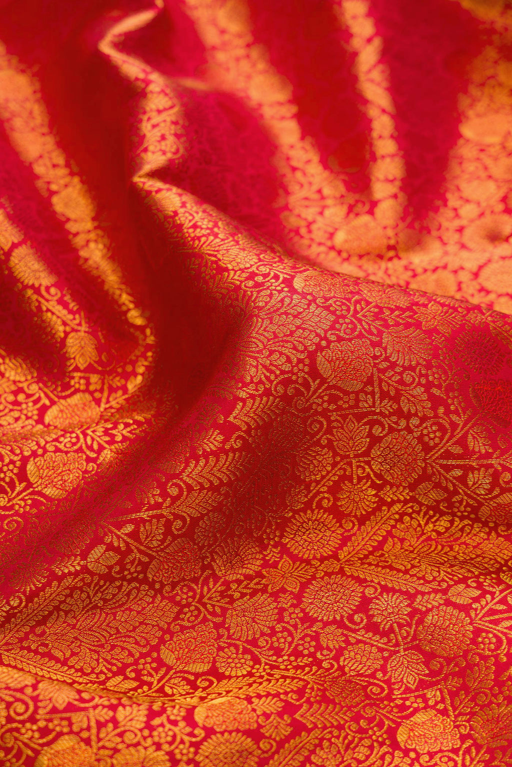 Close up of Brick Orange Kanchipuram Silk Saree with Zari Brocade on the body and Zari Border.  displaying folds