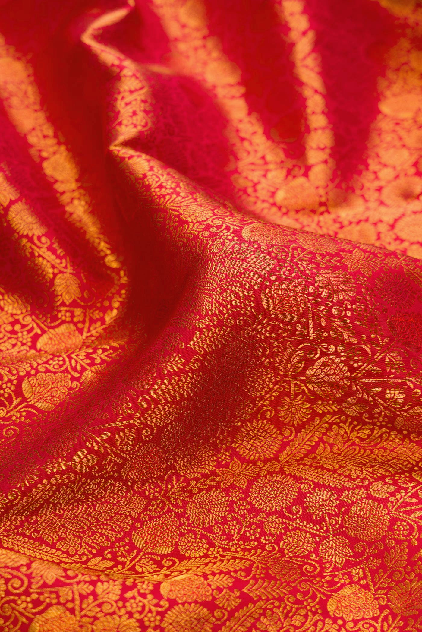 Close up of Brick Orange Kanchipuram Silk Saree with Zari Brocade on the body and Zari Border.  displaying folds