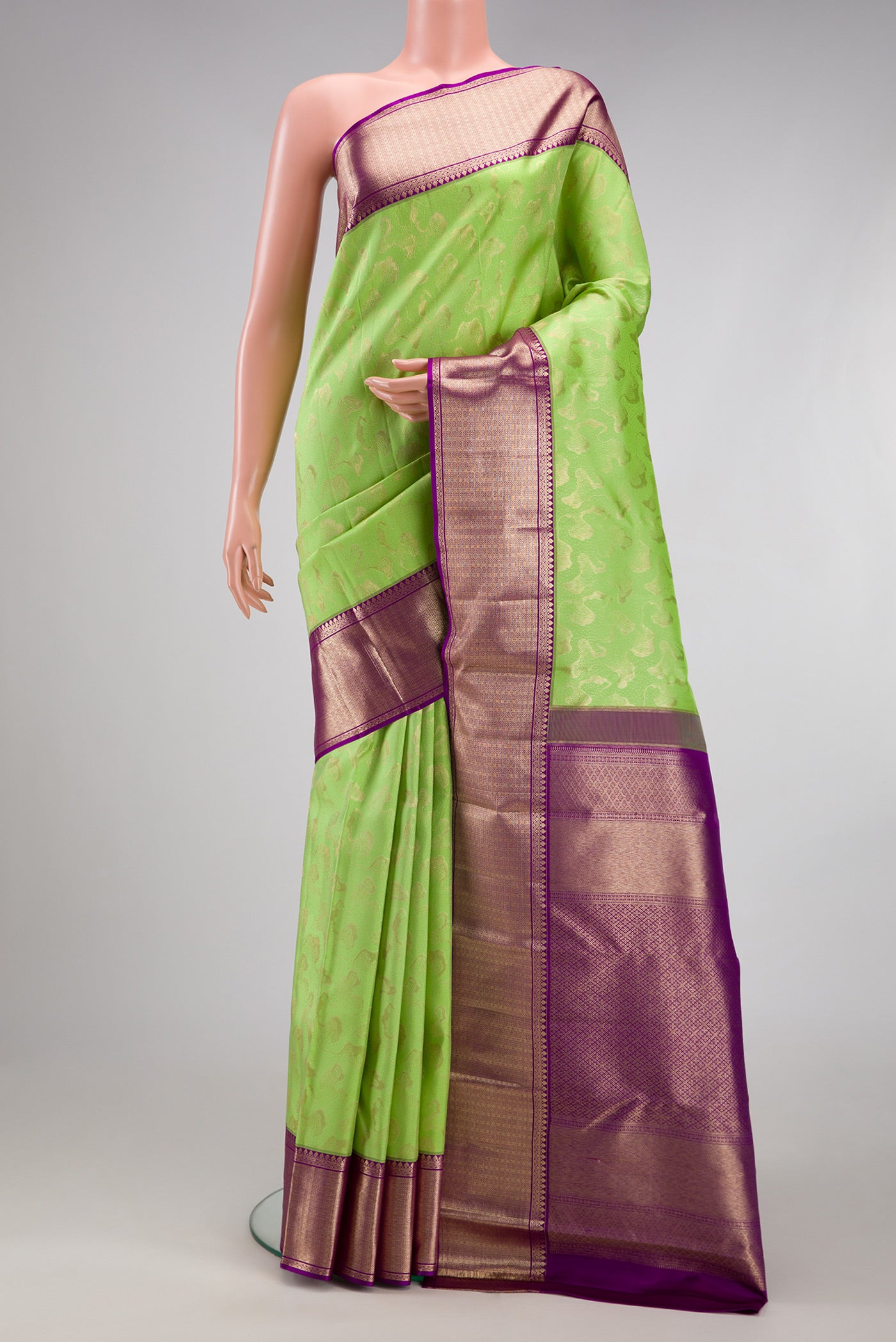 Pista Green Kanchipuram Silk Saree with Zari Brocade on the body and Zari Border.  displayed on a mannequin