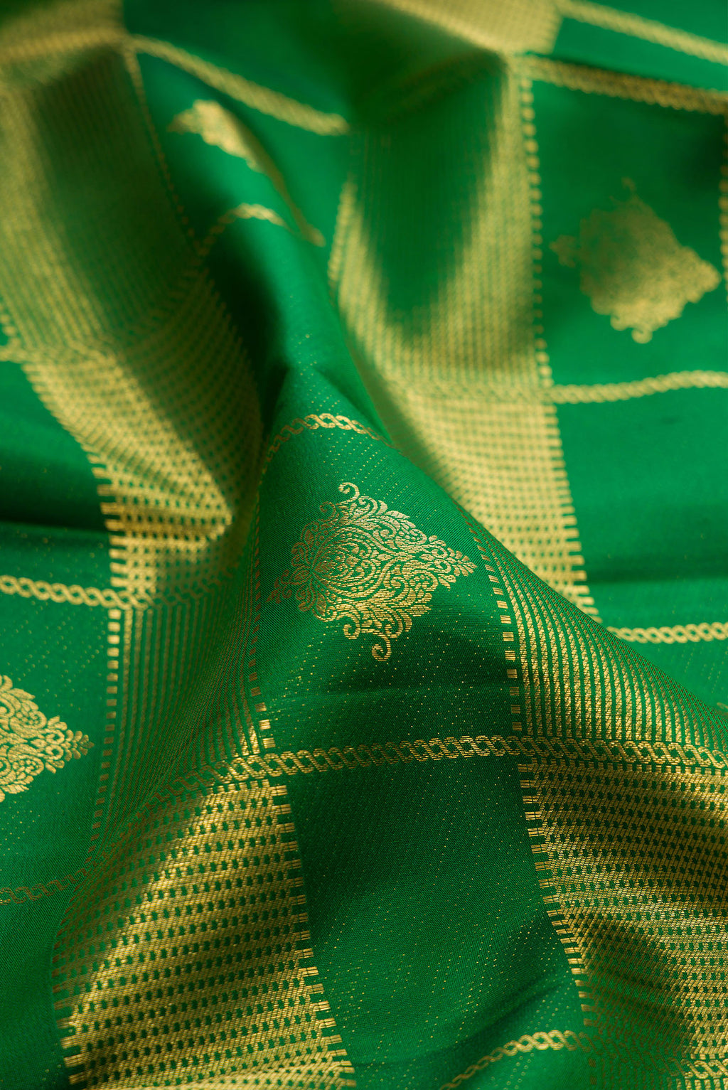 Close up of Green Kanchipuram Silk Saree with Zari Brocade on the body and Zari Border.  displaying folds