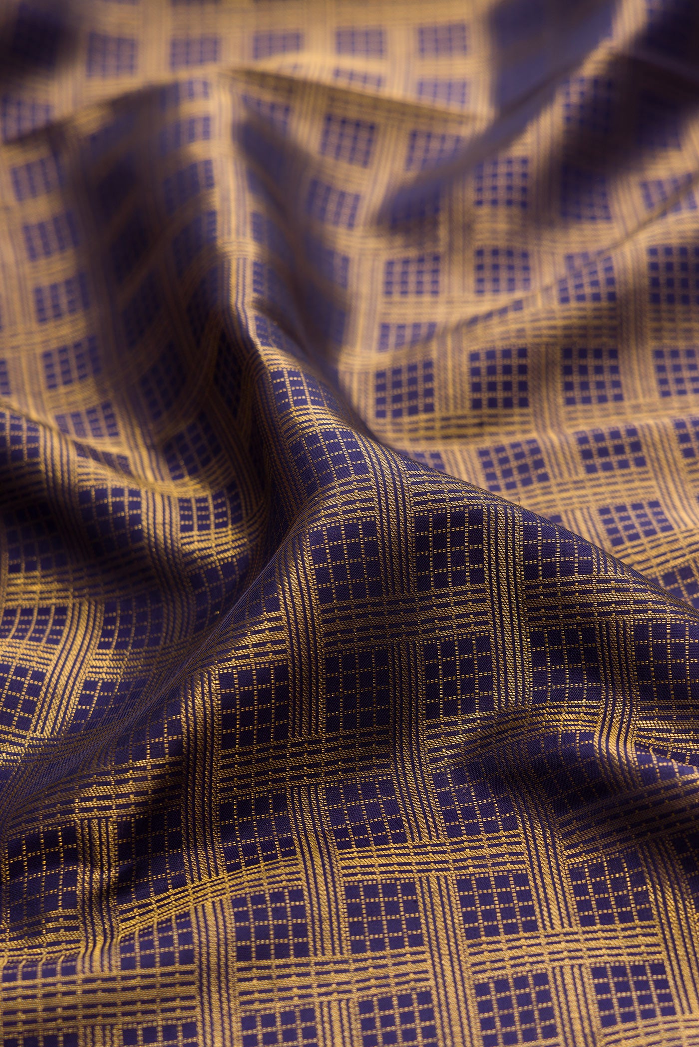 Close up of Navy Blue Kanchipuram Silk Saree with Zari Brocade on the body and Zari Border.  displaying folds