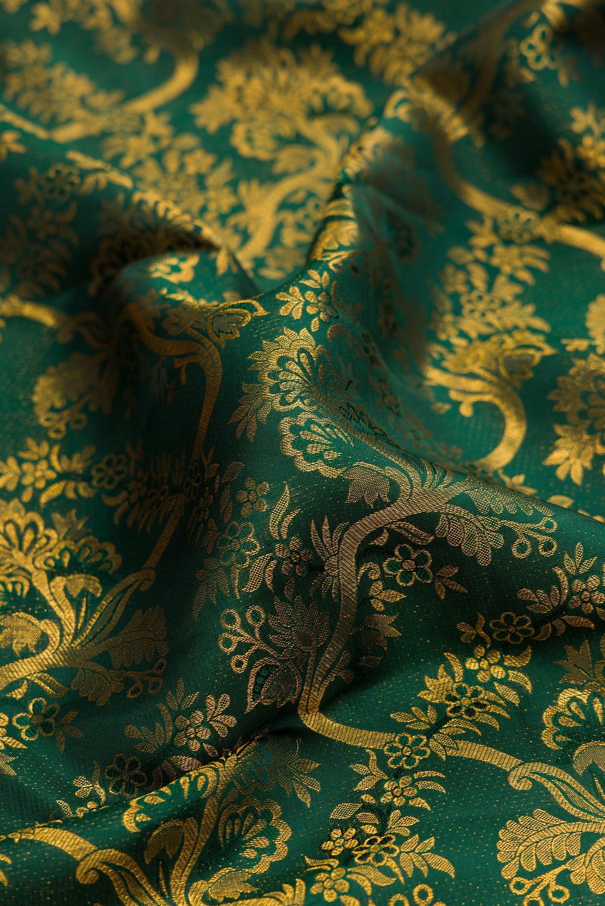 Close up of Pure Silk Bottle Green Kanchipuram Saree with Zari Brocade on the body and Zari Border.  displaying folds