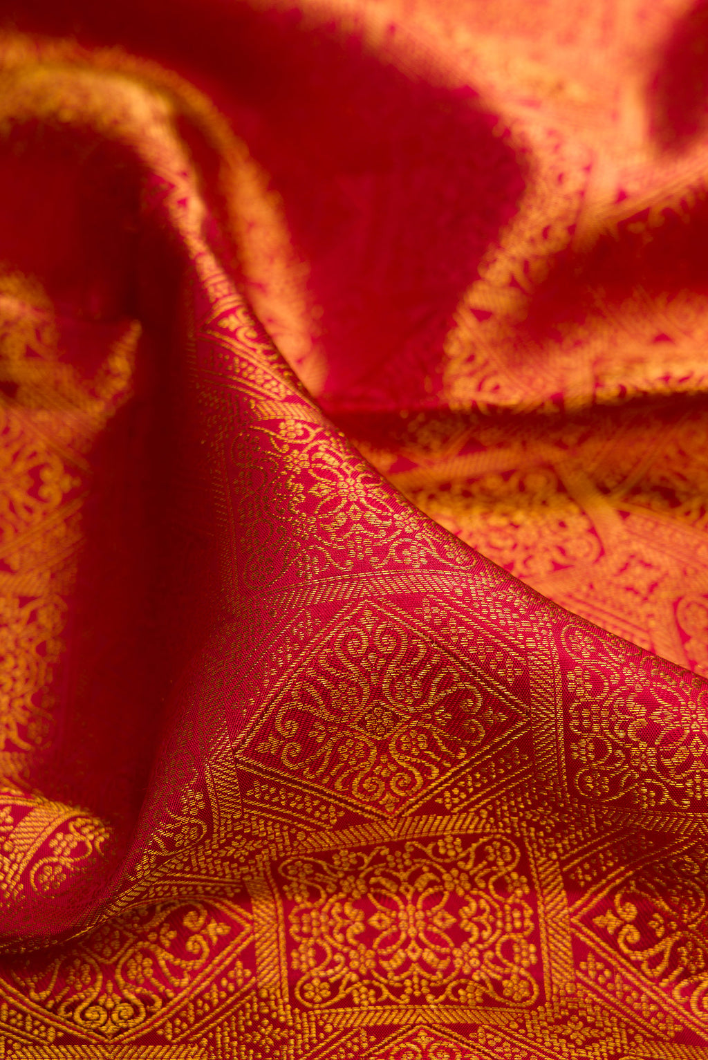 Close up of Pure Silk Red Kanchipuram Saree with Zari Brocade on the body and Zari Border.  displaying folds