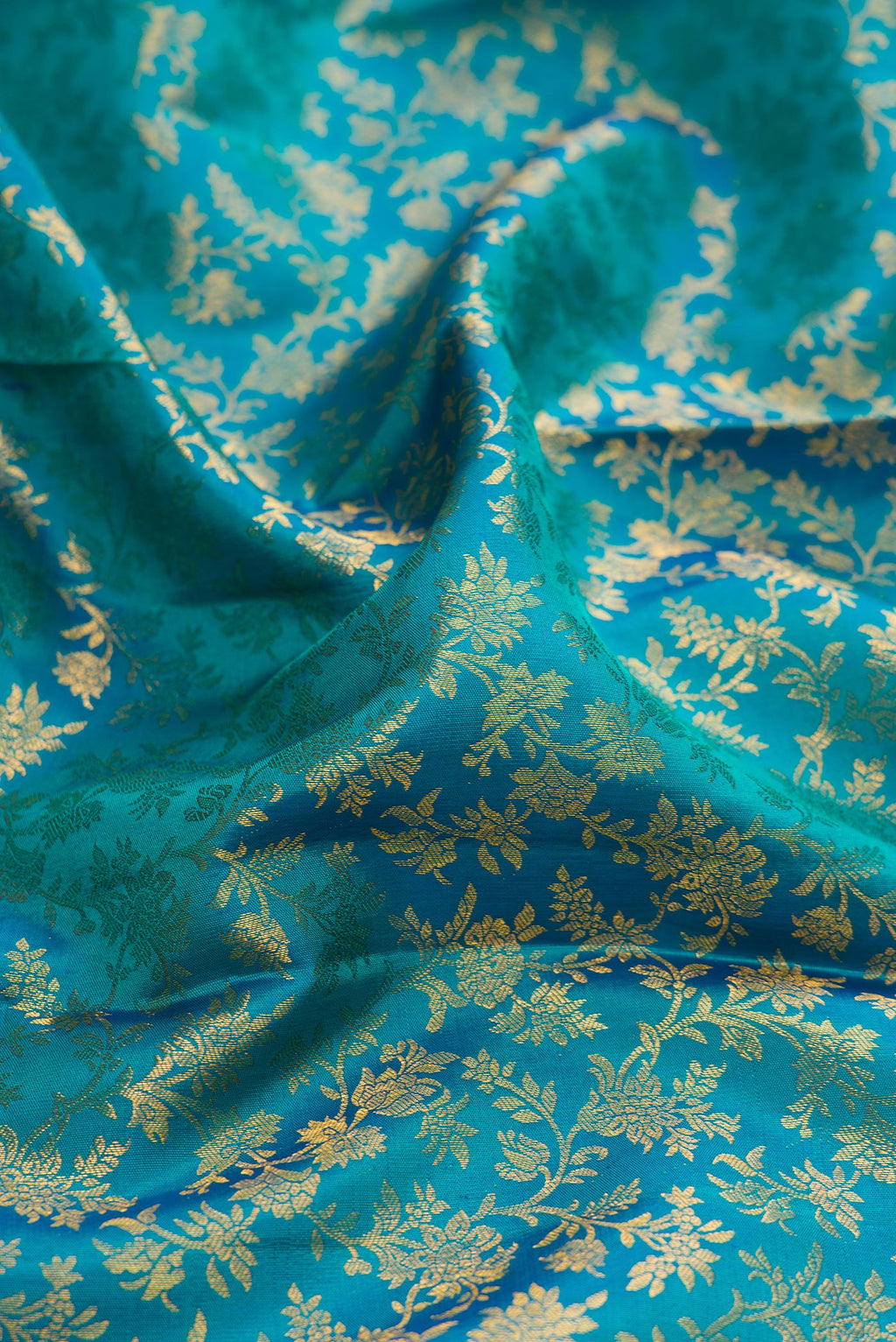 Close up of Teal Kanchipuram Silk Saree with Zari Brocade on the body and Zari Border.  displaying folds