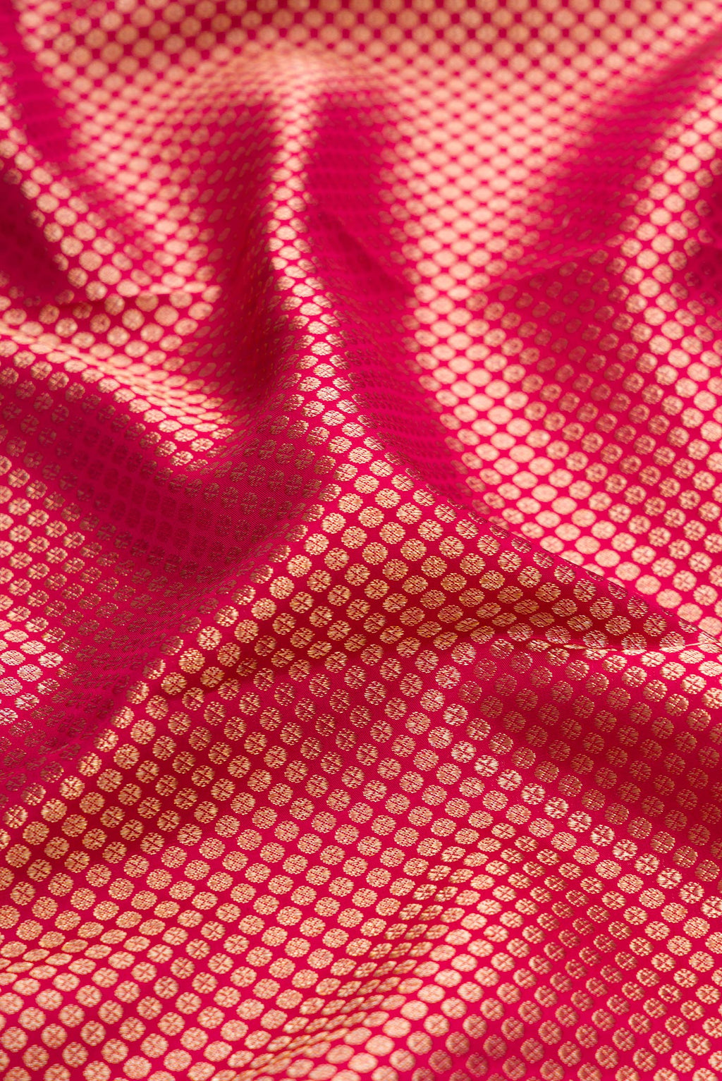 Close up of Rani Pink Kanchipuram Silk Saree with Zari Brocade on the body and Zari Border.  displaying folds
