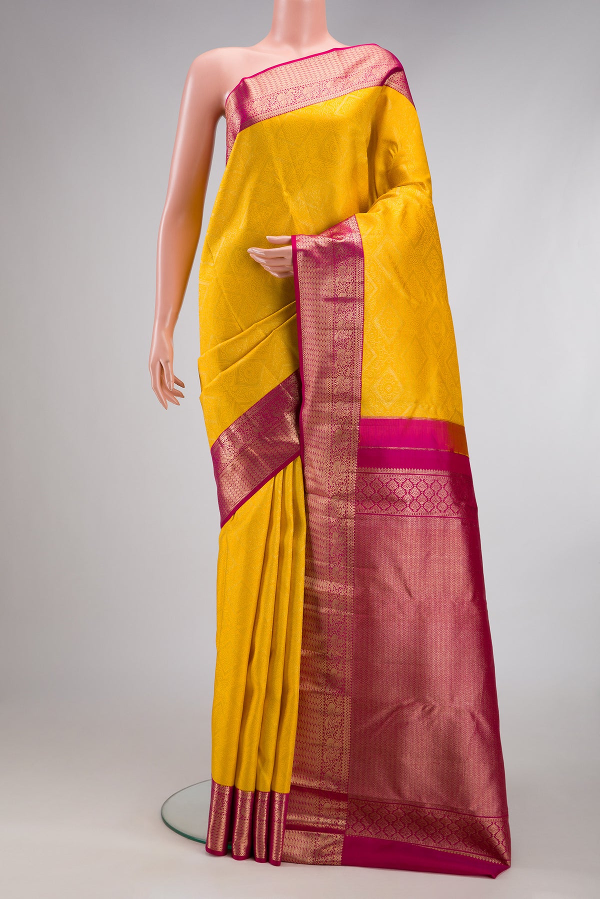 Yellow Kanjivaram Silk Saree with Zari Brocade on the body and Zari Border.  displayed on a mannequin