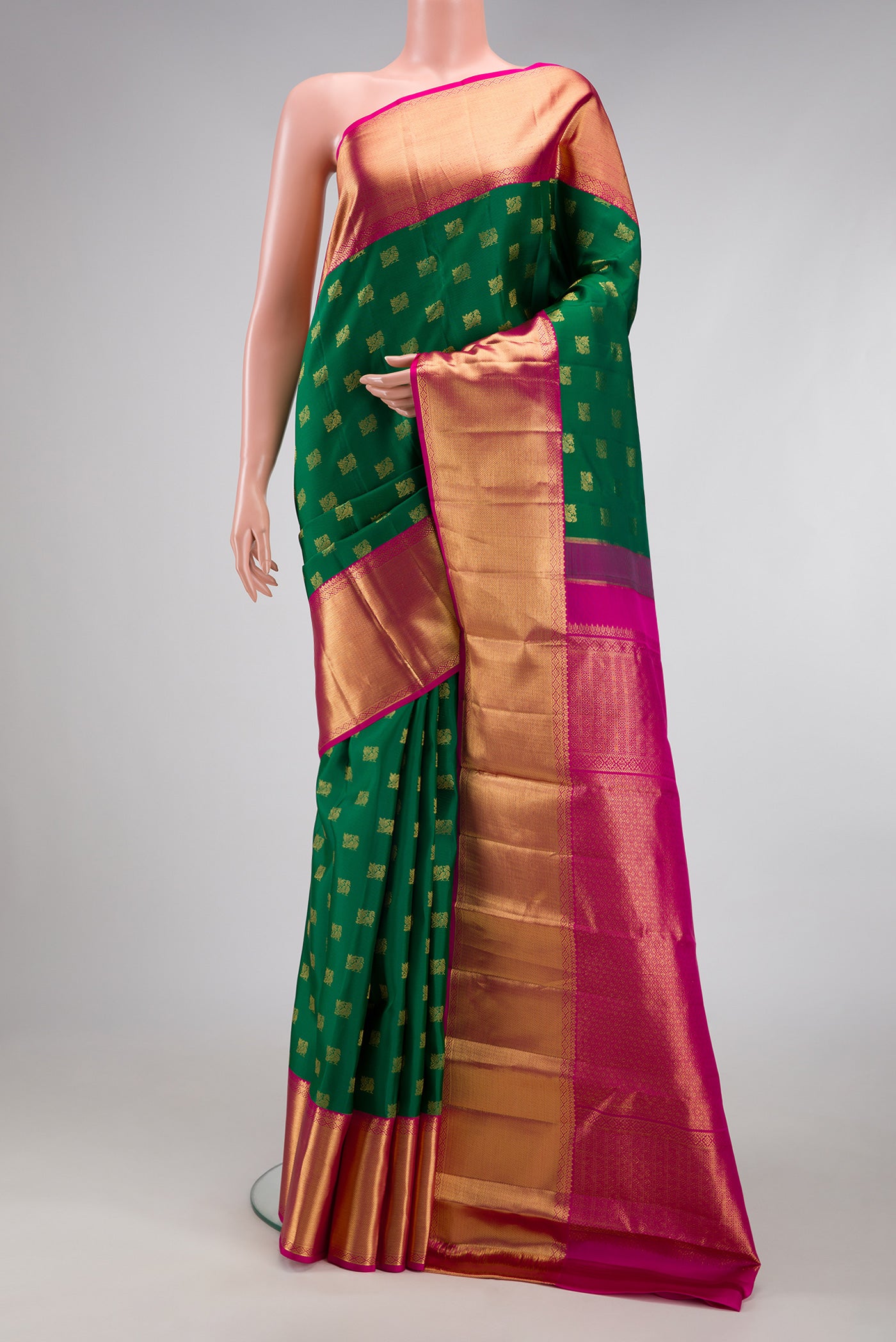 Green Kanjivaram Silk Saree with Zari Butta on the body and Zari Border.  displayed on a mannequin
