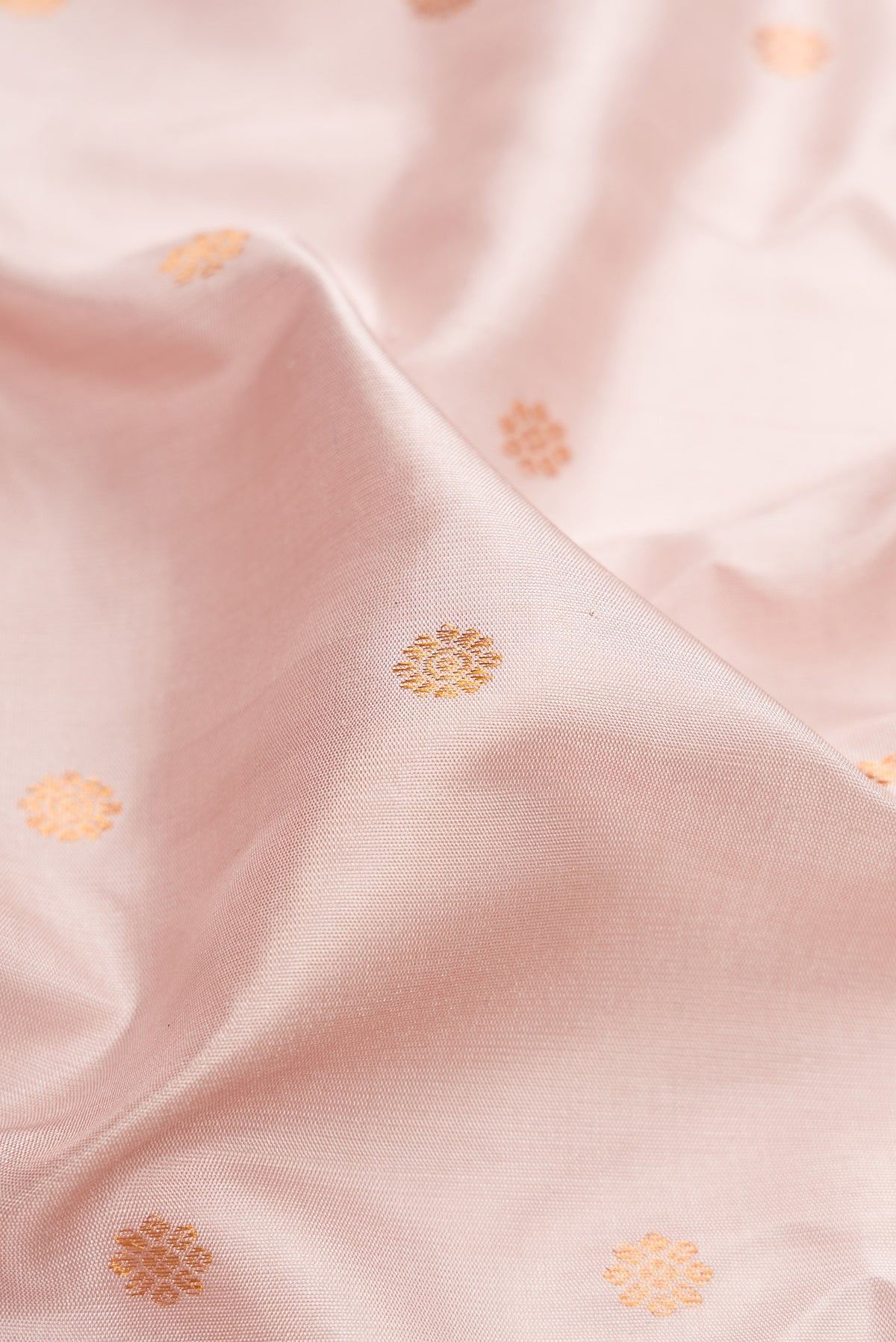 Close up of Rose Gold Gadwal Silk Saree with Zari Butta on the body and Temple Border.  displaying folds