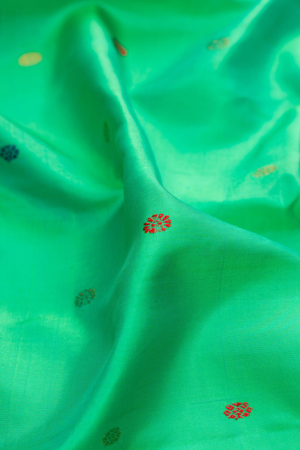 Close up of Green Gadwal Silk Saree with Thread Butta on the body and Zari Border.  displaying folds
