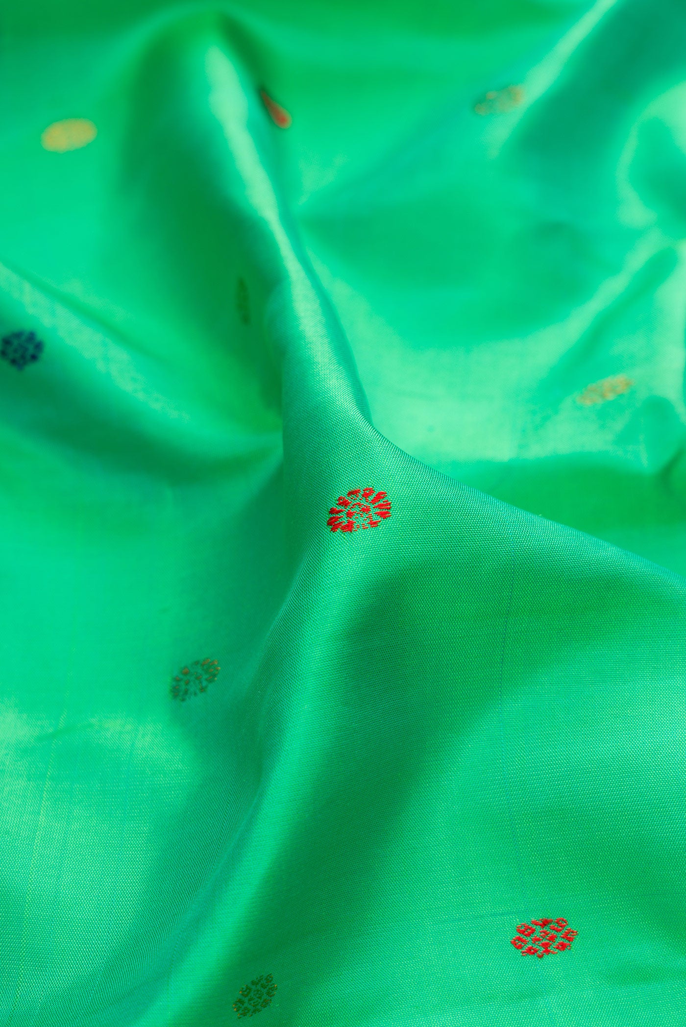 Close up of Green Gadwal Silk Saree with Thread Butta on the body and Zari Border.  displaying folds