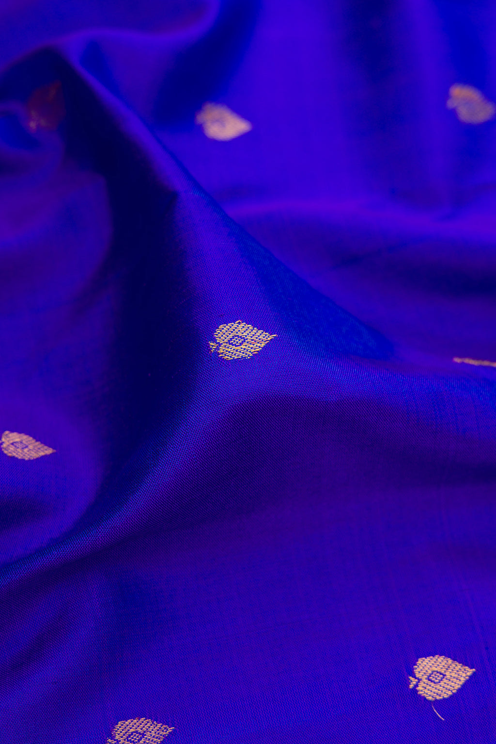 Close up of Royal Blue Gadwal Silk Saree with Zari Butta on the body and Temple Border.  displaying folds