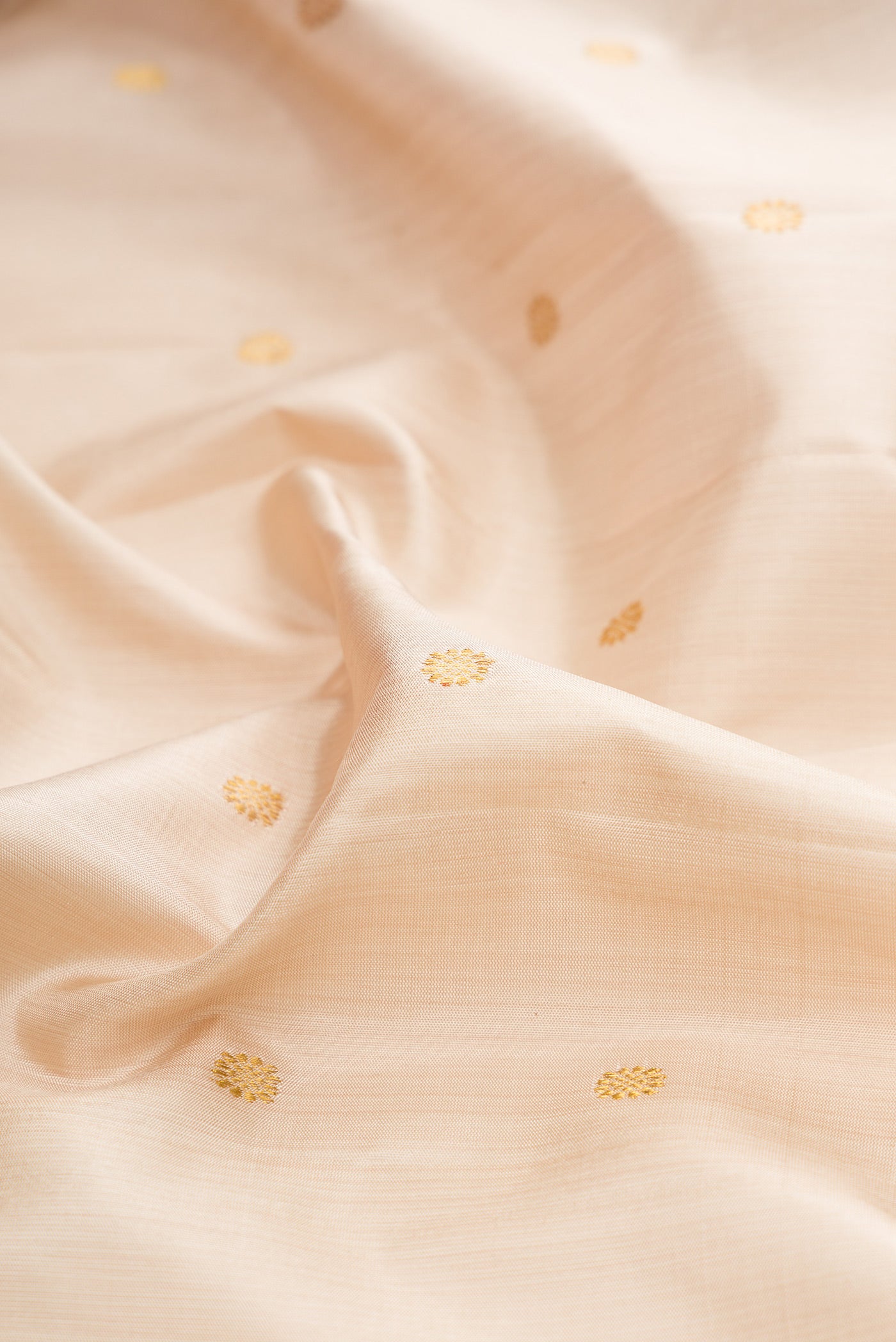 Close up of Beige Gadwal Silk Saree with Zari Butta on the body and Zari Border.  displaying folds