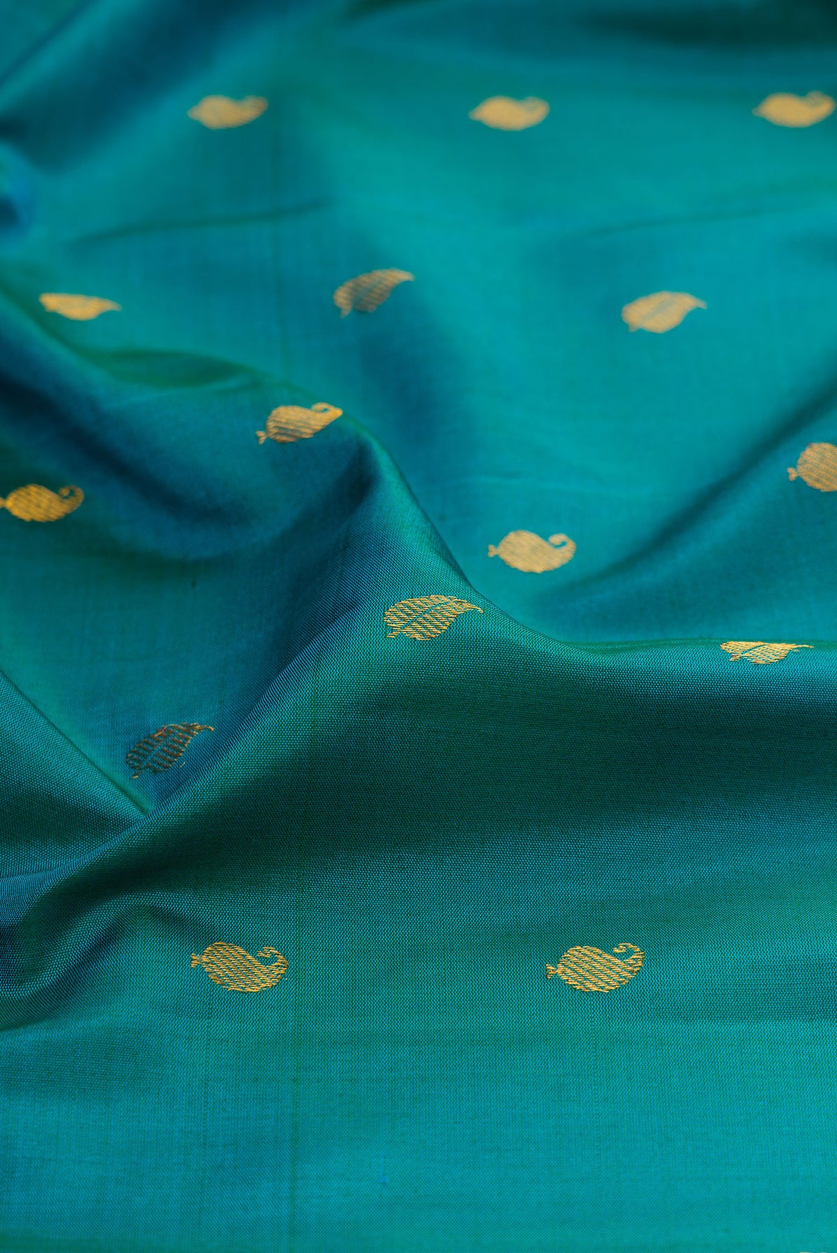 Close up of Peacock Blue Gadwal Silk Saree with Zari Butta on the body and Zari Border.  displaying folds