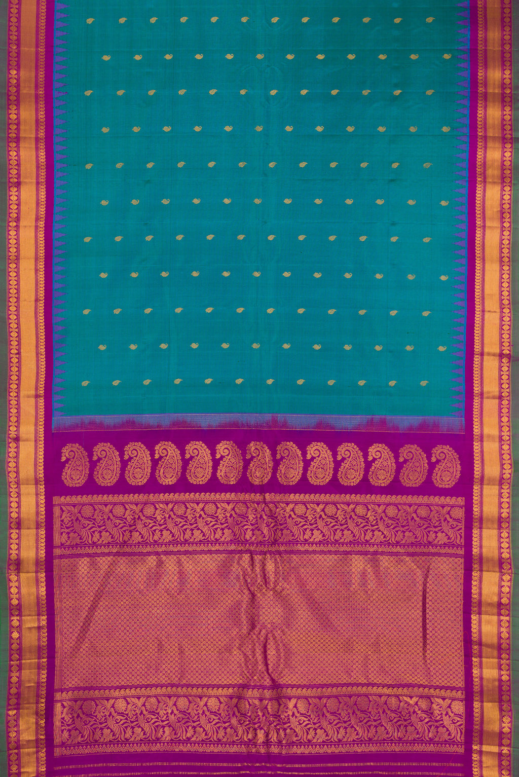 Flat view of Peacock Blue Gadwal Silk Saree with Zari Butta on the body and Zari Border. 