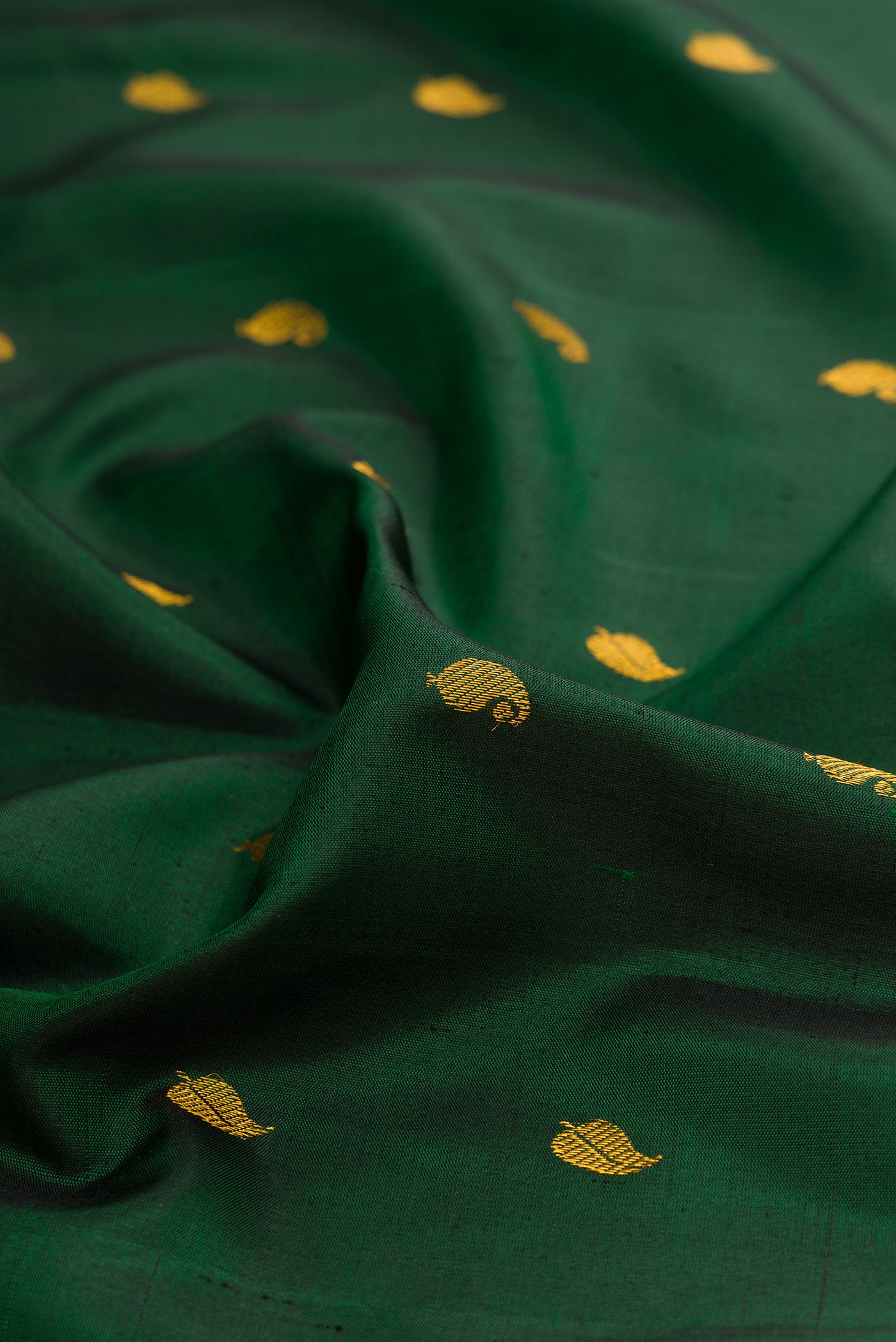 Close up of Bottle Green Gadwal Silk Saree with Zari Butta on the body and Zari Border.  displaying folds