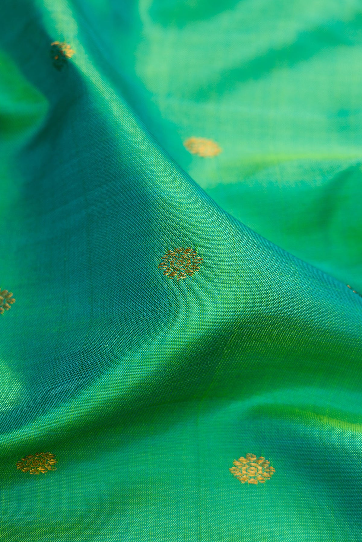Close up of Sea Green Dual Tone Gadwal Silk Saree with Zari Butta on the body and Temple Border.  displaying folds