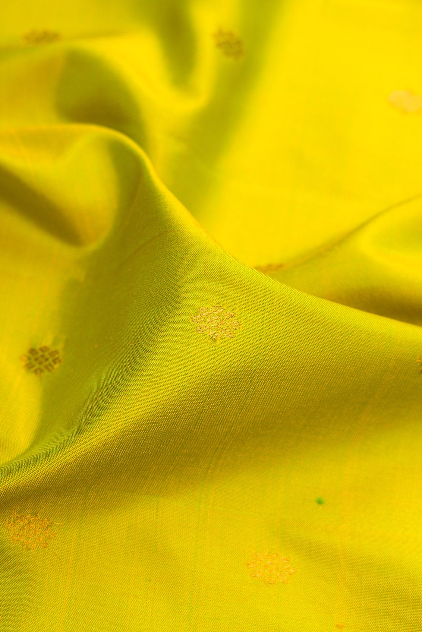 Close up of Parrot Green Gadwal Silk Saree with Zari Butta on the body and Temple Border.  displaying folds