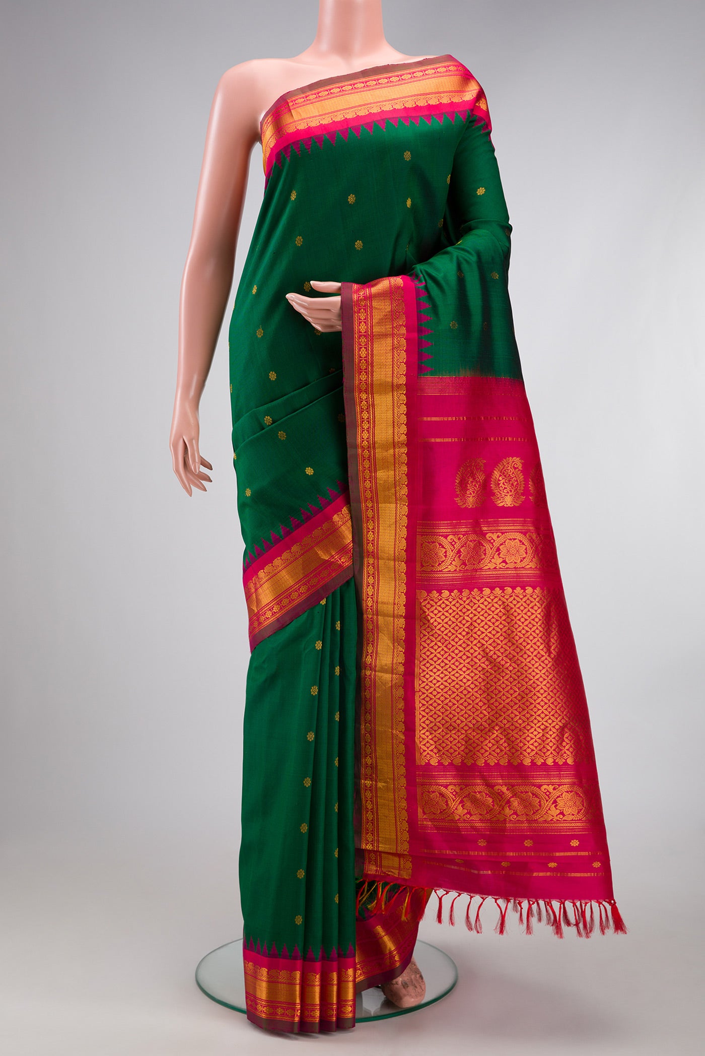 Bottle Green Gadwal Silk Saree with Zari Butta on the body and Temple Border.  displayed on a mannequin