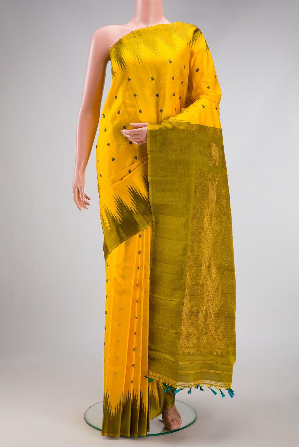 Yellow Gadwal Silk Saree with Thread Butta on the body and Temple Border.  displayed on a mannequin