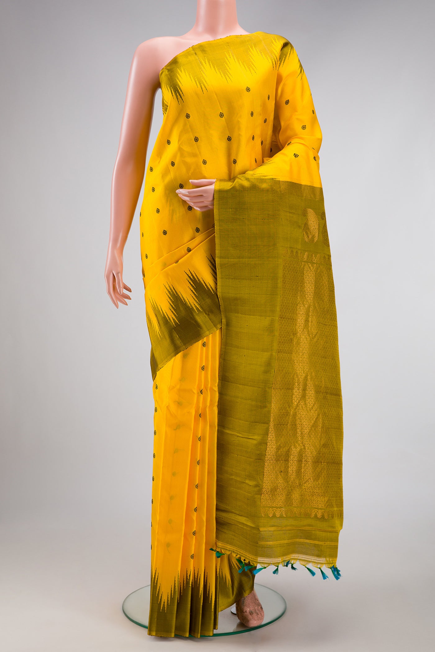 Yellow Gadwal Silk Saree with Thread Butta on the body and Temple Border.  displayed on a mannequin
