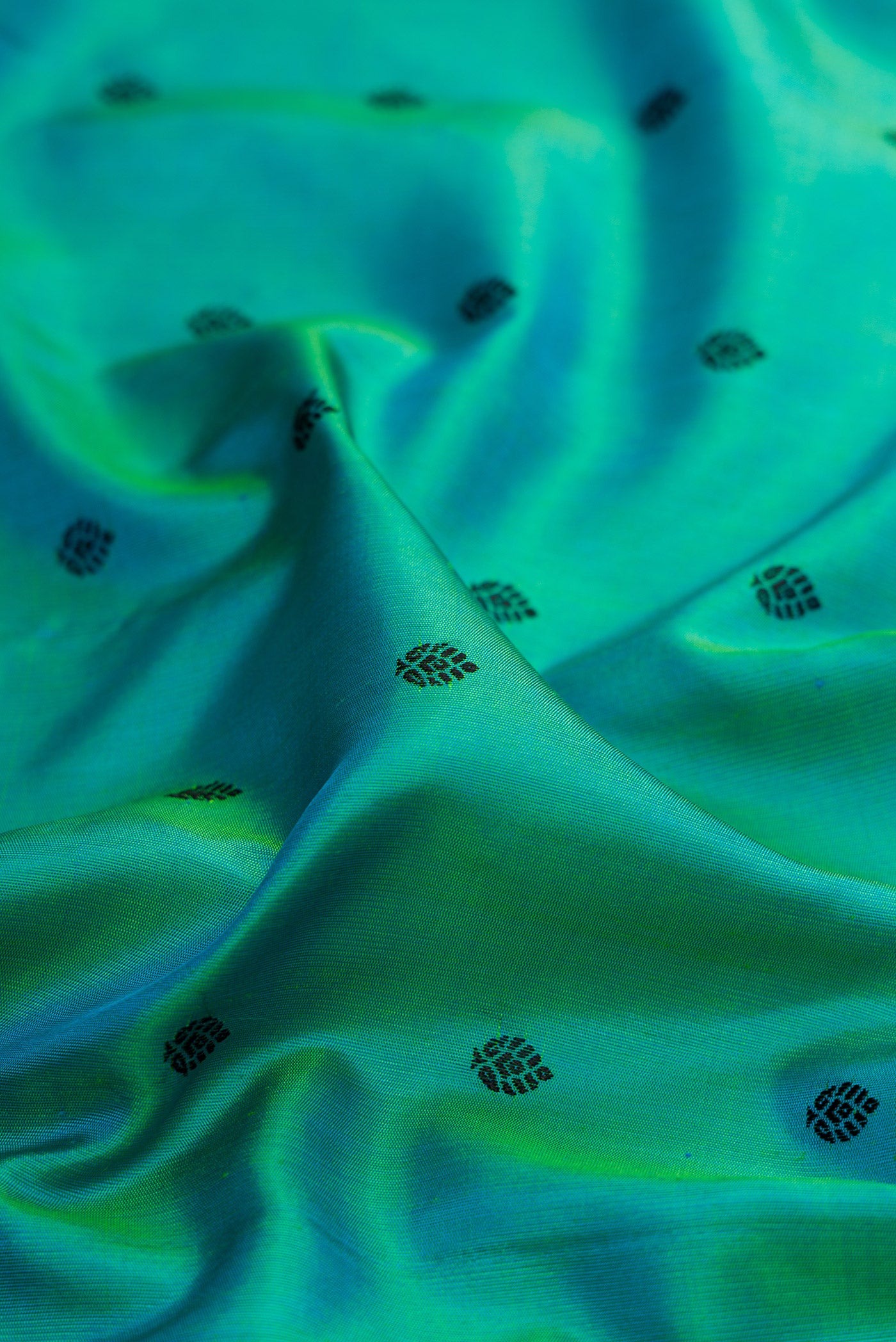 Close up of Sea Green Dual Tone Gadwal Silk Saree with Thread Butta on the body and Temple Border.  displaying folds