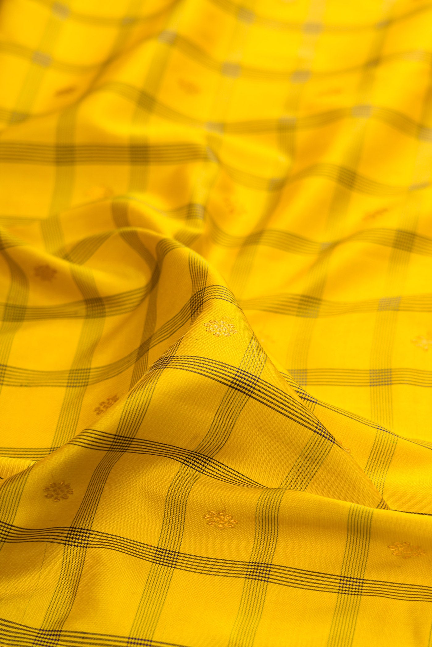 Close up of Yellow Gadwal Silk Saree with Checked design on the body and Temple Border.  displaying folds
