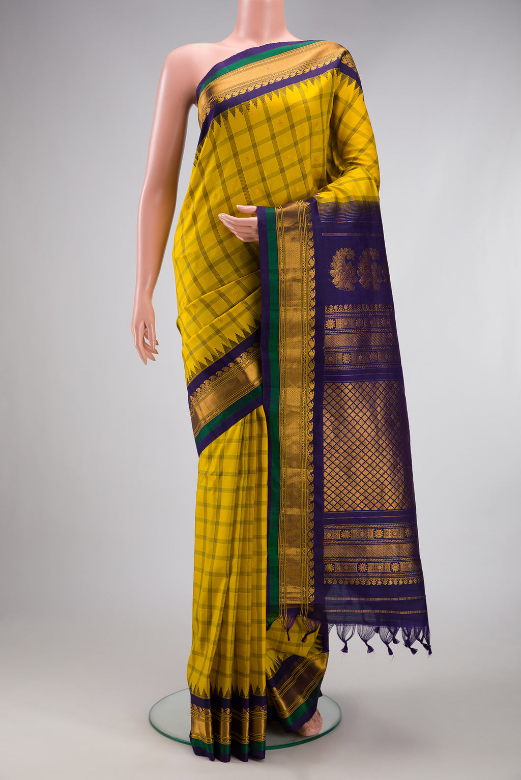Yellow Gadwal Silk Saree with Checked design on the body and Temple Border.  displayed on a mannequin