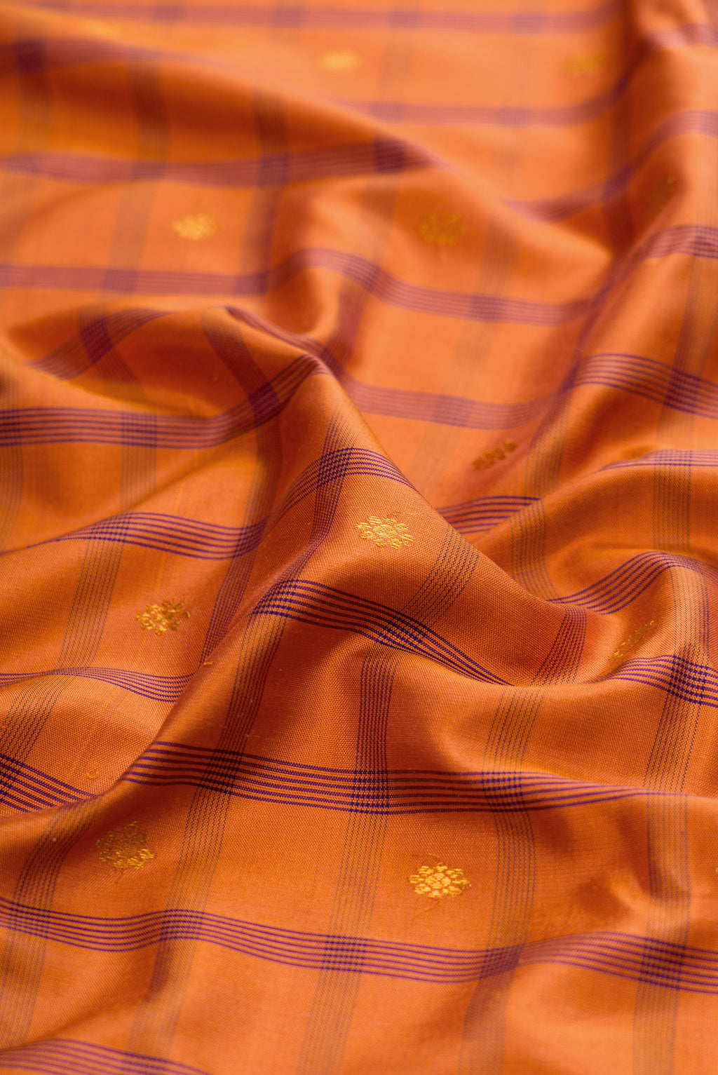 Close up of Brick Orange Gadwal Silk Saree with Checked design on the body and Zari Border.  displaying folds