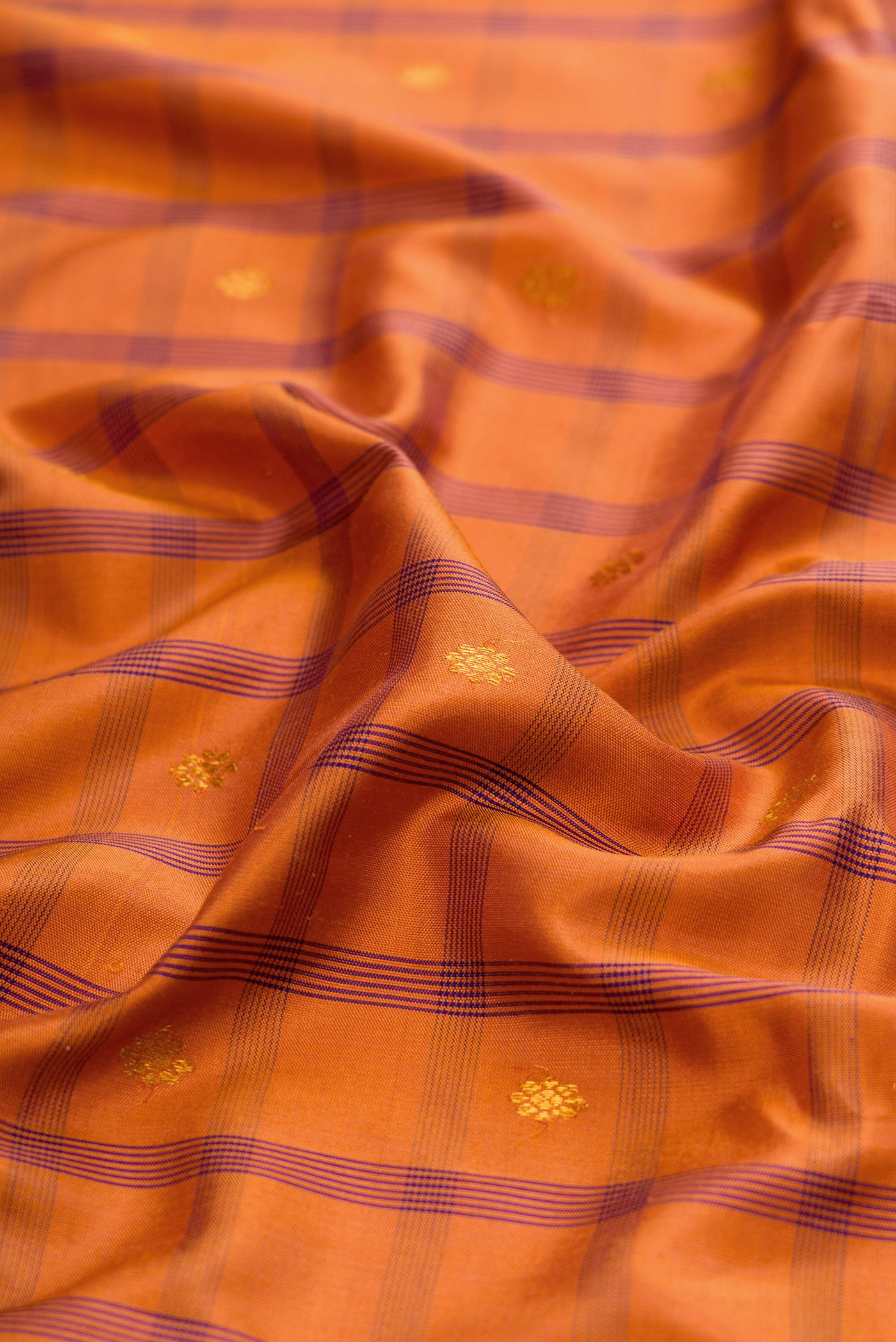 Close up of Brick Orange Gadwal Silk Saree with Checked design on the body and Zari Border.  displaying folds