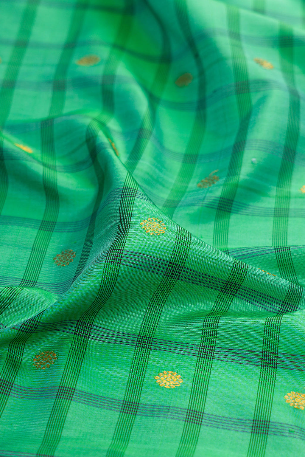 Close up of Sea Green Gadwal Silk Saree with Checked design on the body and Temple Border.  displaying folds