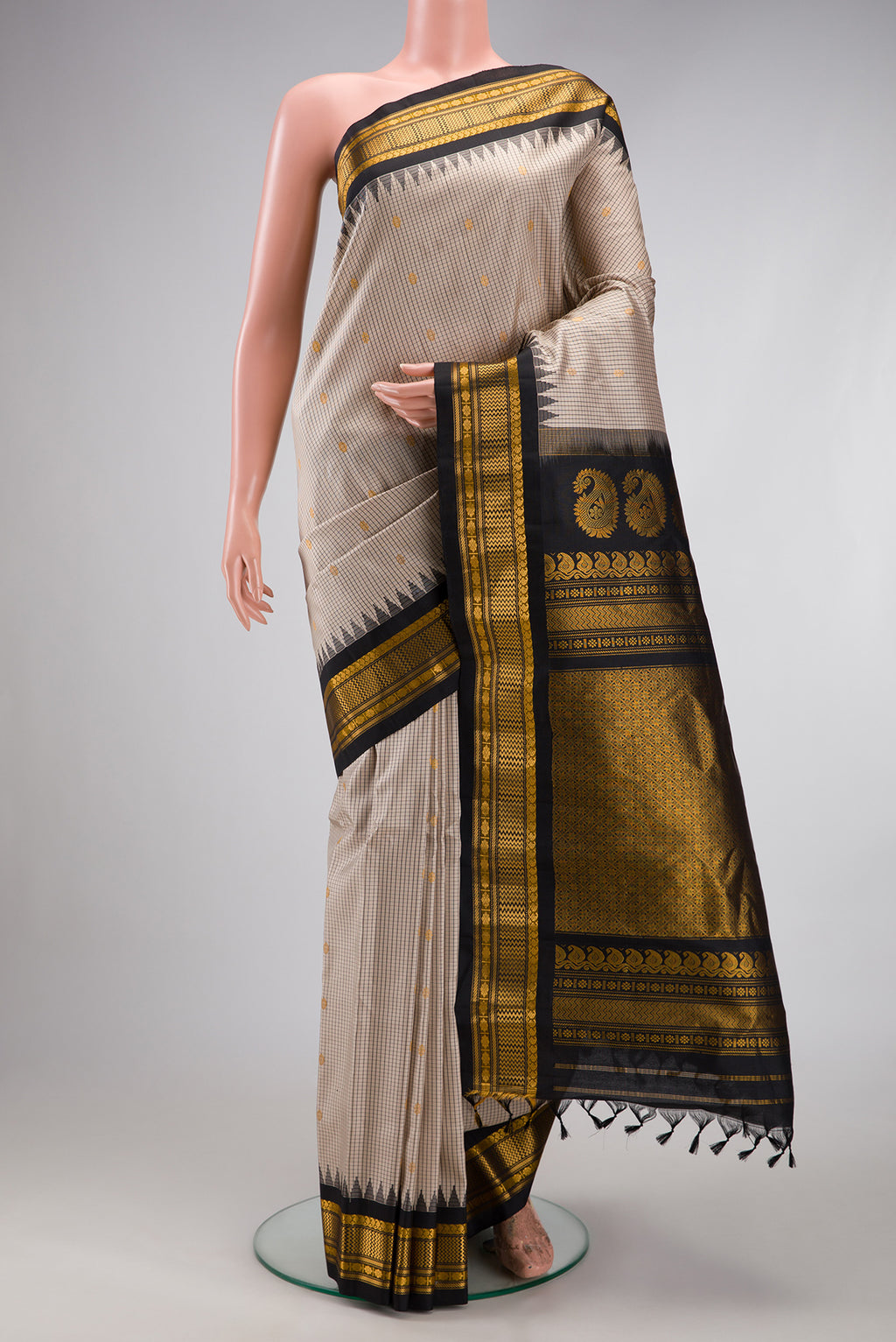 Beige Gadwal Silk Saree with Checked design on the body and Temple Border.  displayed on a mannequin