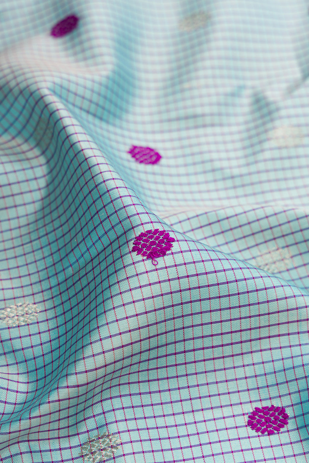 Close up of Light Blue Gadwal Silk Saree with Checked design on the body and Temple Border.  displaying folds