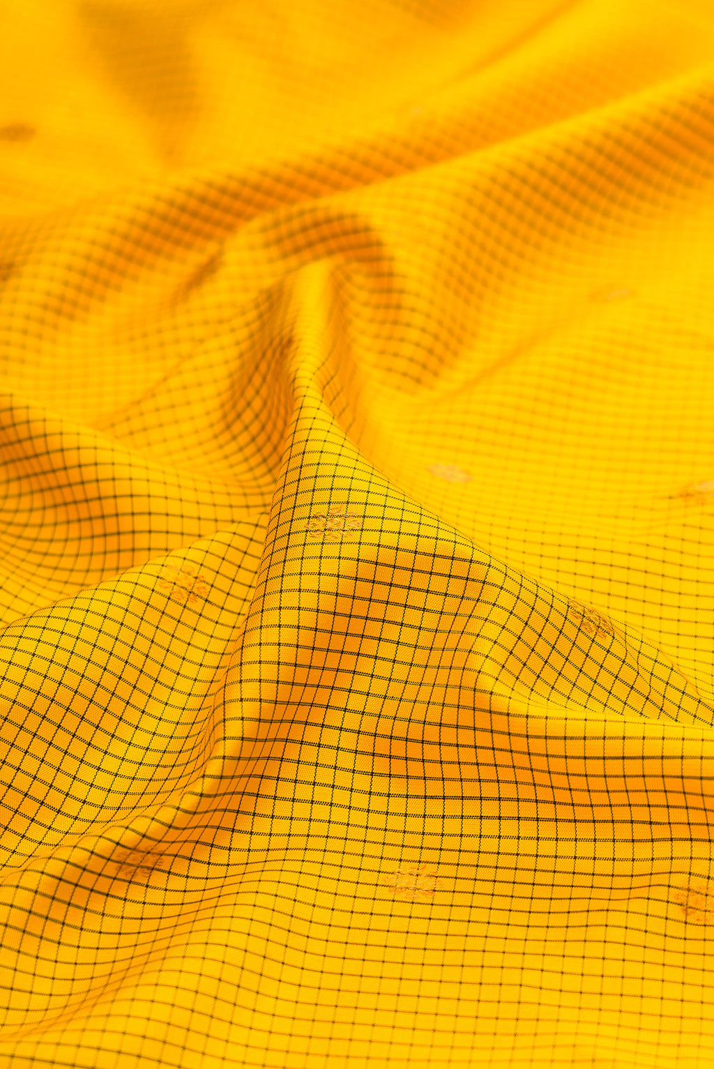 Close up of Yellow Gadwal Silk Saree with Checked design on the body and Temple Border.  displaying folds