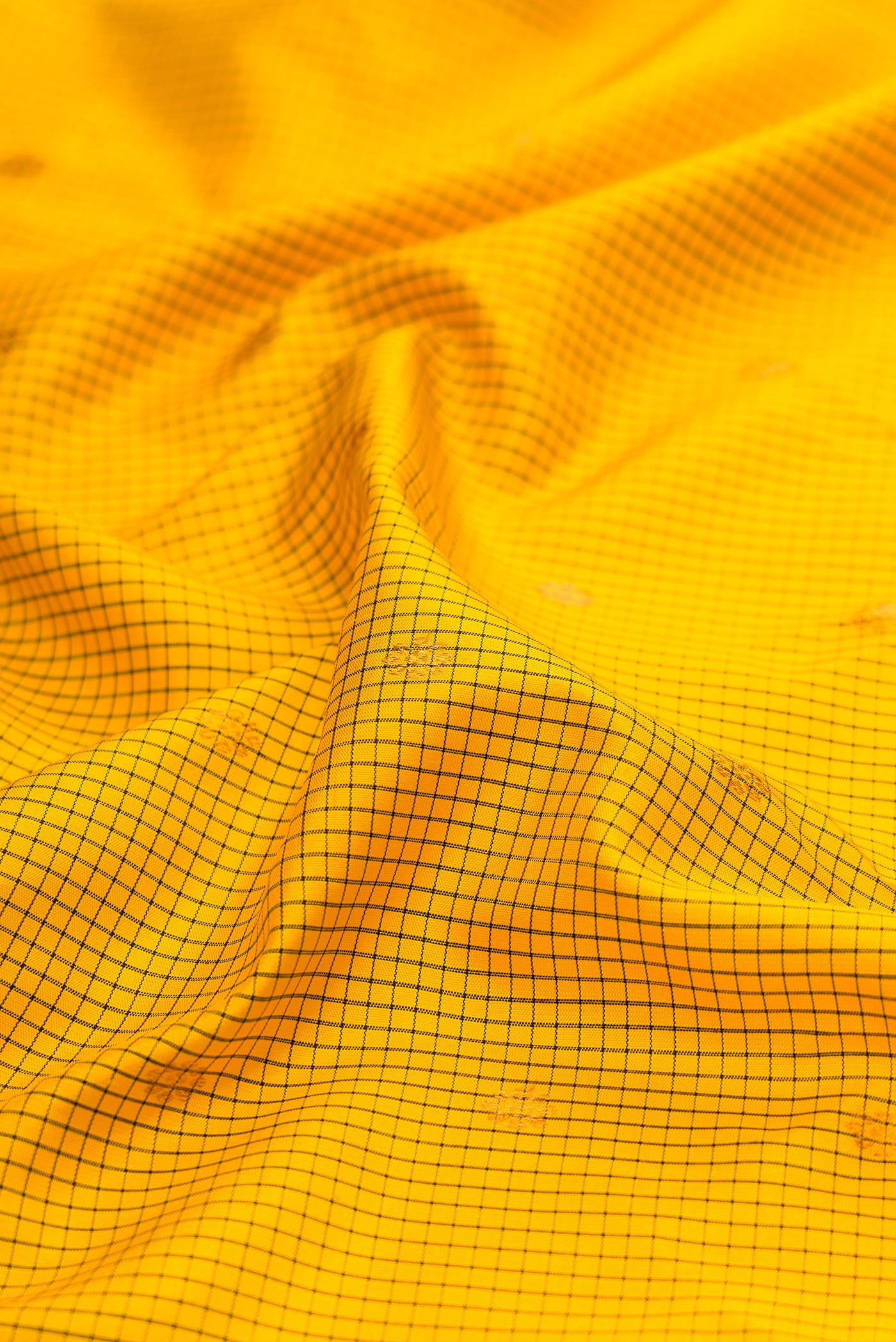 Close up of Yellow Gadwal Silk Saree with Checked design on the body and Temple Border.  displaying folds