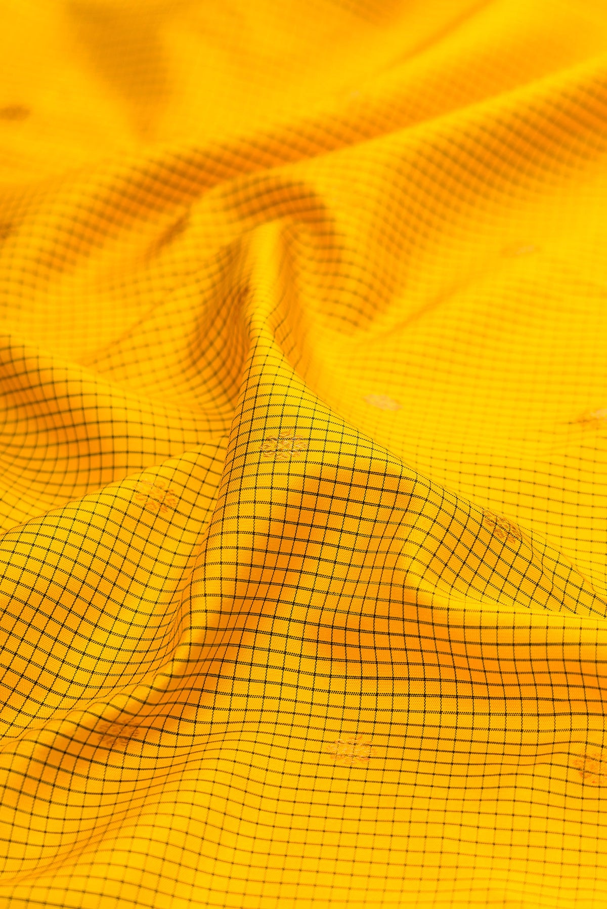 Close up of Yellow Gadwal Silk Saree with Checked design on the body and Temple Border.  displaying folds
