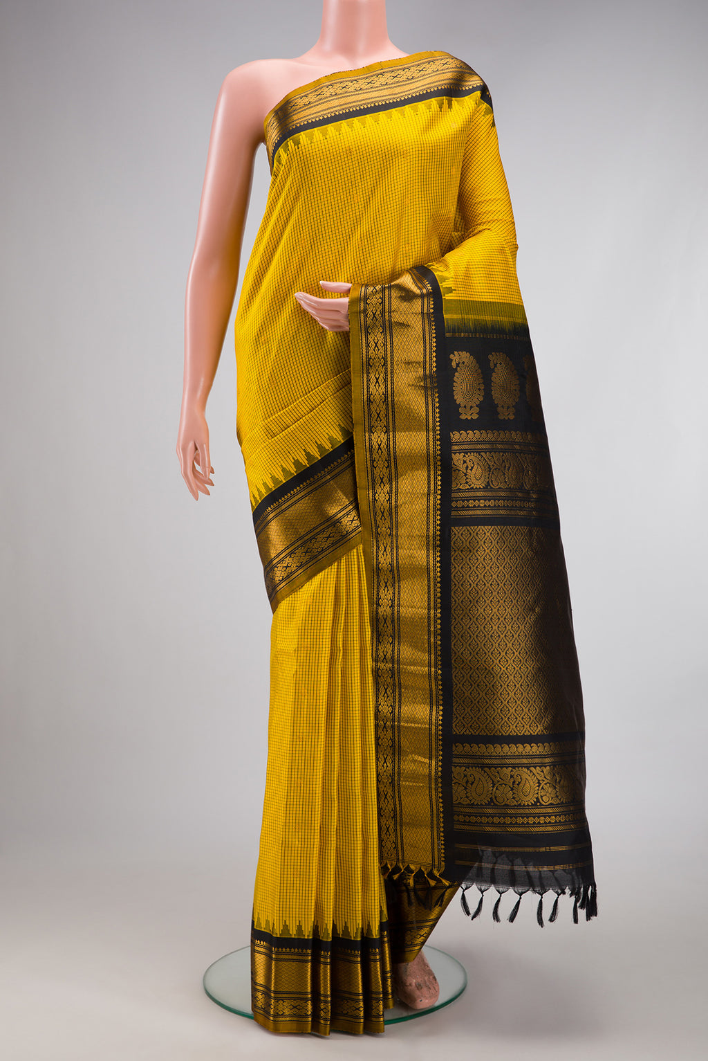 Yellow Gadwal Silk Saree with Checked design on the body and Temple Border.  displayed on a mannequin