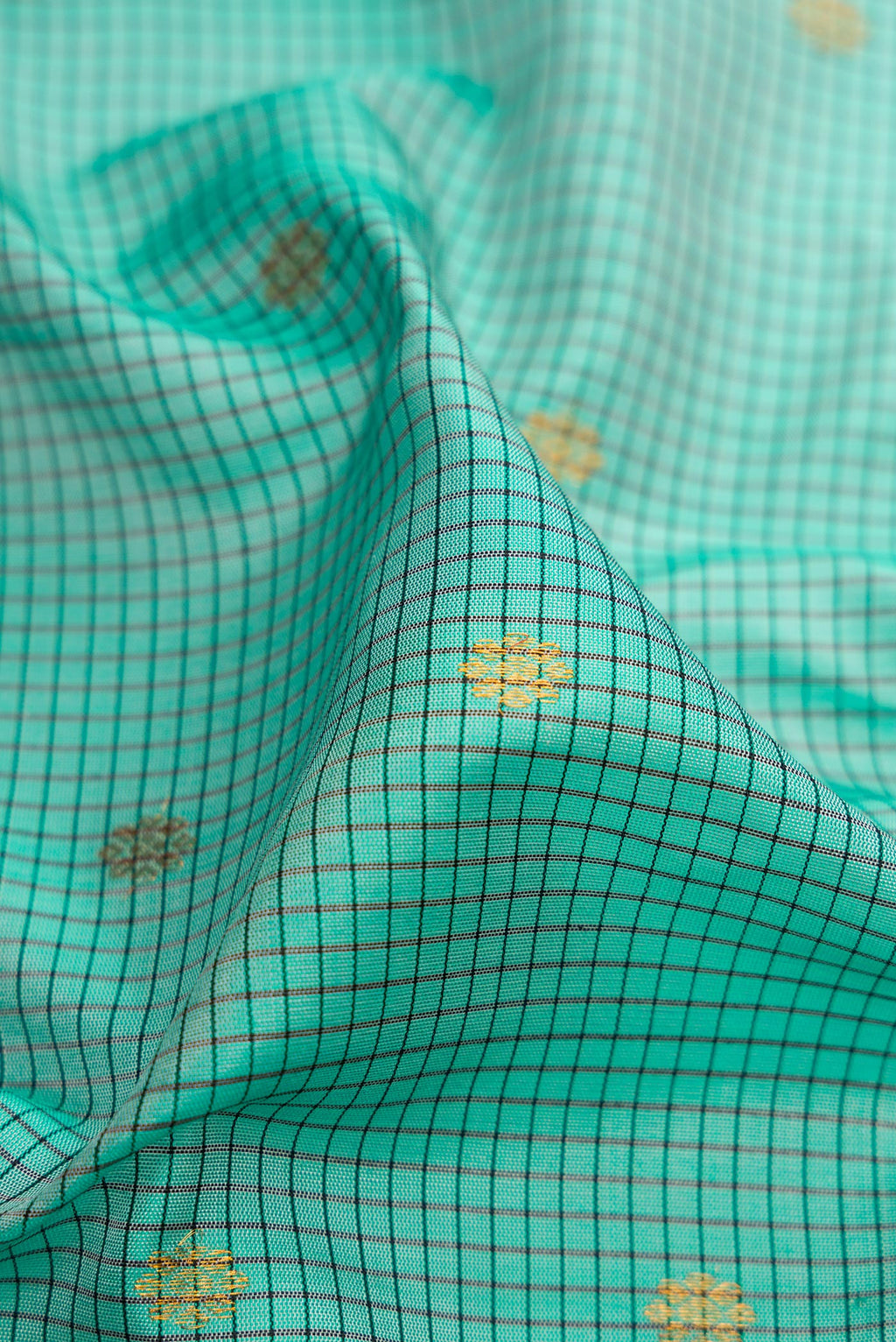 Close up of Sea Green Gadwal Silk Saree with Checked design on the body and Temple Border.  displaying folds