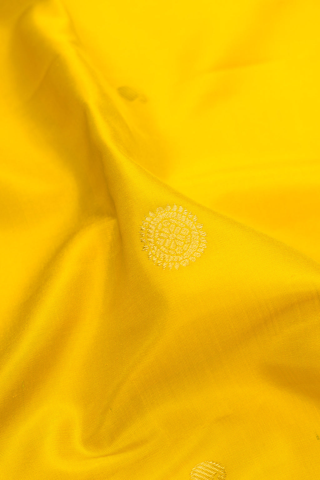 Close up of Yellow Gadwal Silk Saree with Zari Butta on the body and Temple Border.  displaying folds
