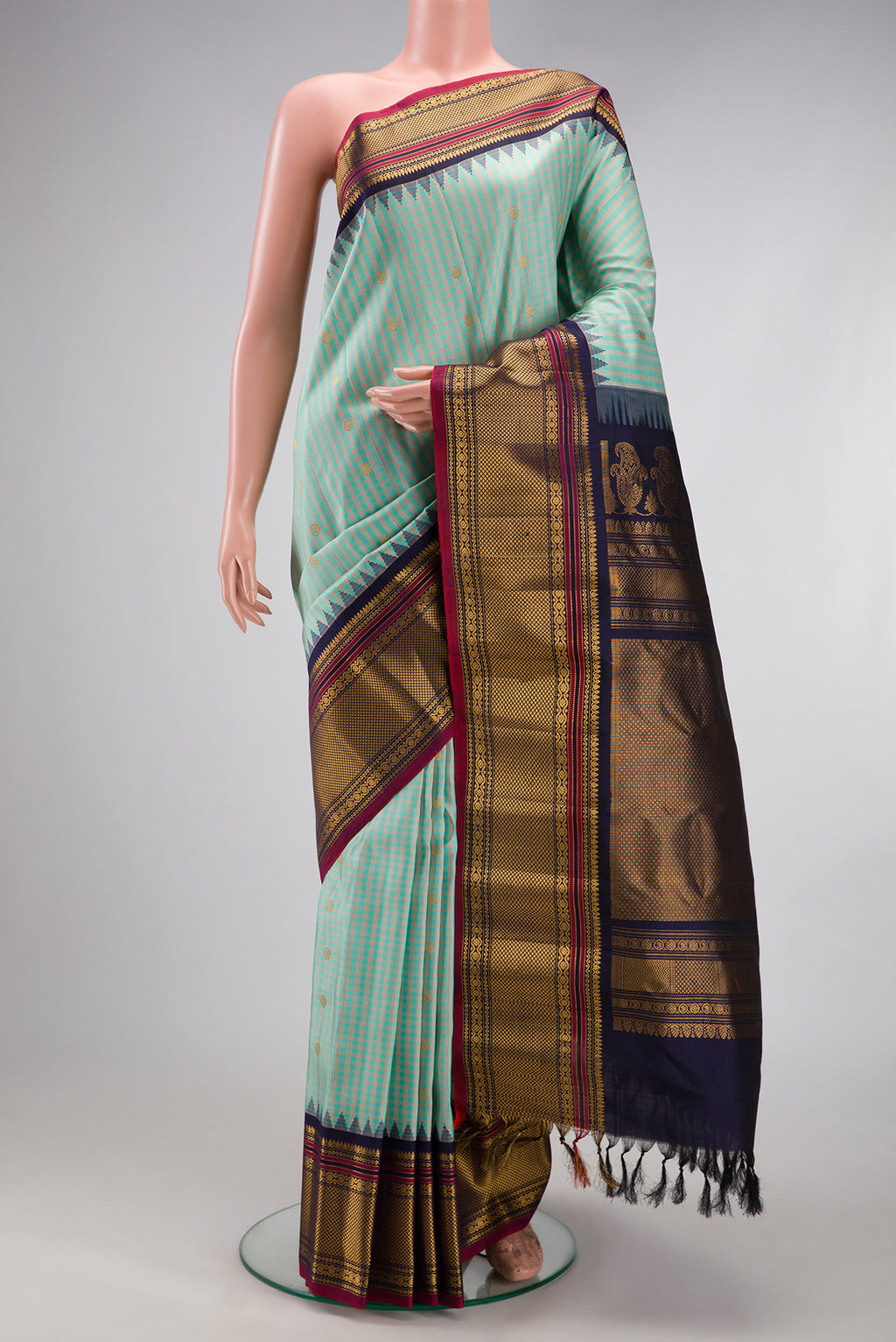 Light Blue Gadwal Silk Saree with Checked design on the body and Temple Border.  displayed on a mannequin